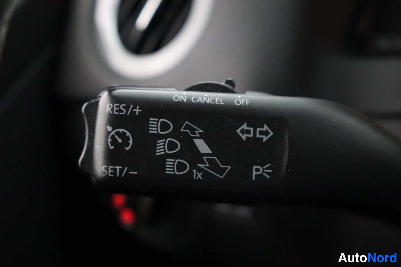 Yksityiskohta: Lähikuva Volkswagenin varrenvarresta, jonka merkeissä lukevat RES/+, SET/–, ON, CANCEL, OFF ja P sekä valaistus- ja suuntavilkkusymbolit.