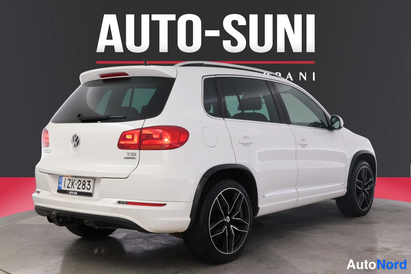 Takaviisto: Valkoinen Volkswagen Tiguan takaa vasemmalta, rekisteritunnus ja TSI 4MOTION-tunus takaluukussa.