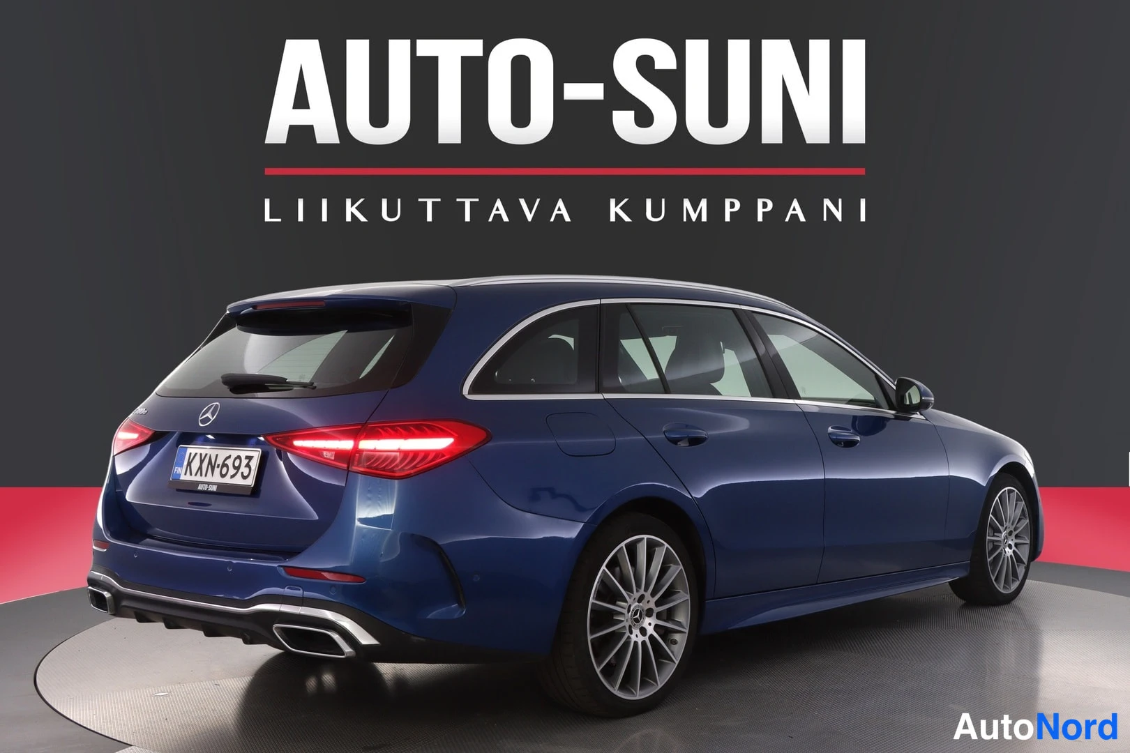 Takaviisto: Tummansininen Mercedes-Benz C -farmari takakulmasta, takavalot ja rekisteritunnus näkyvissä.