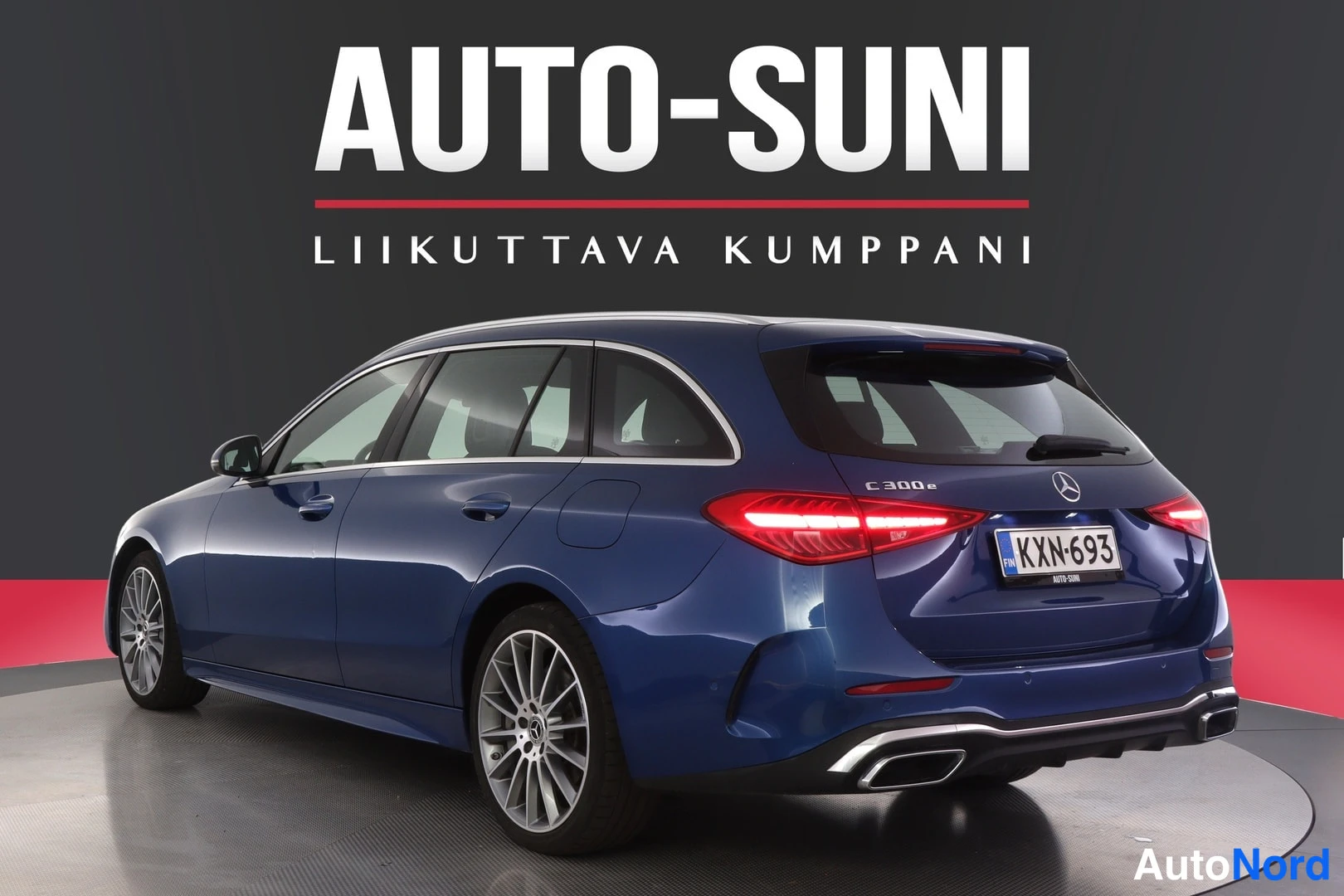 Takaviisto: Tummansininen Mercedes-Benz C -farmari takakulmasta, peräosassa C 300e -merkintä ja rekisteritunnus.