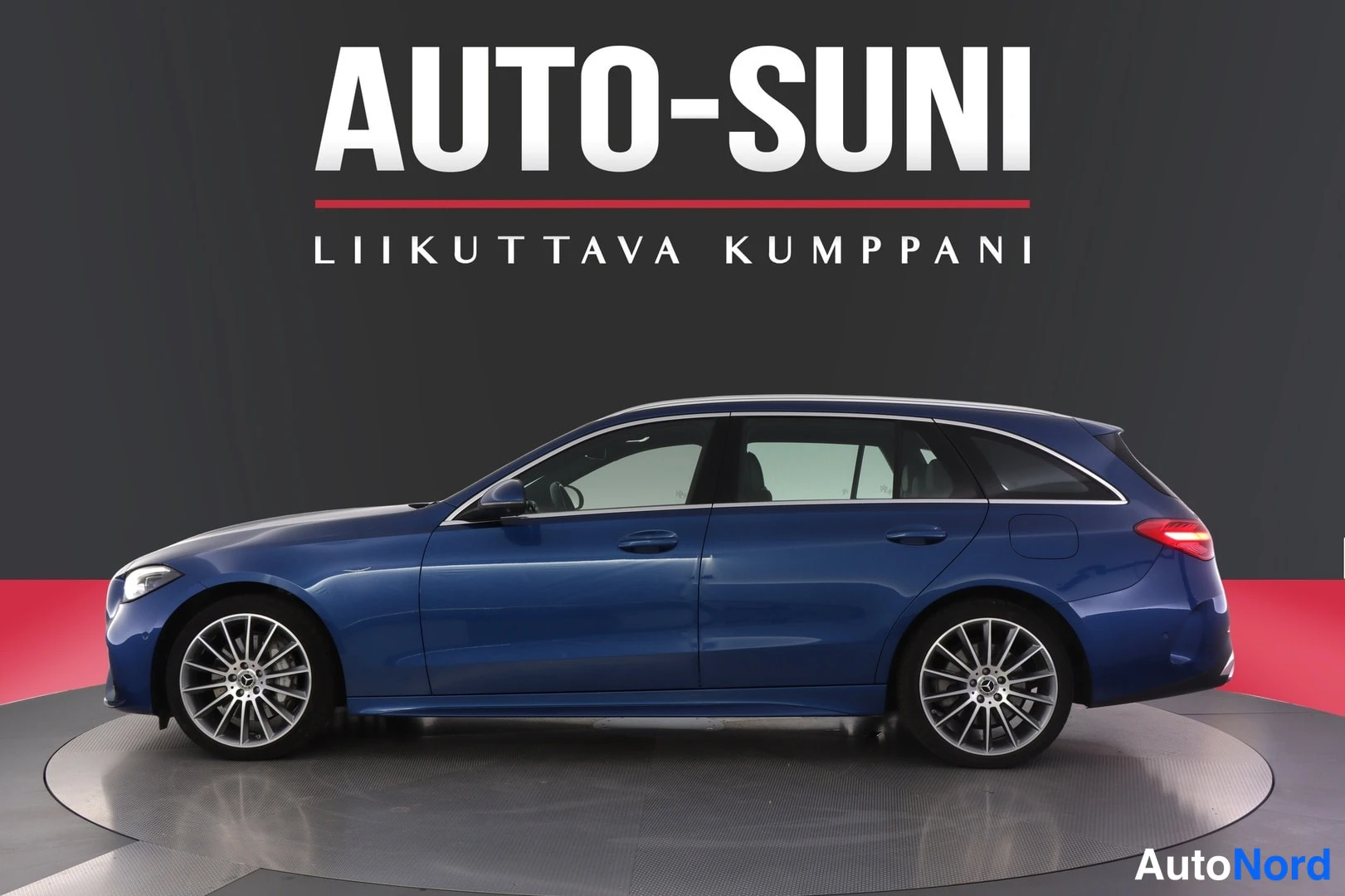 Sivulta: Sininen Mercedes-Benz farmarikori sivuprofiilista, AUTO-SUNI Liikuttava kumppani -teksti kuvan yläosassa.