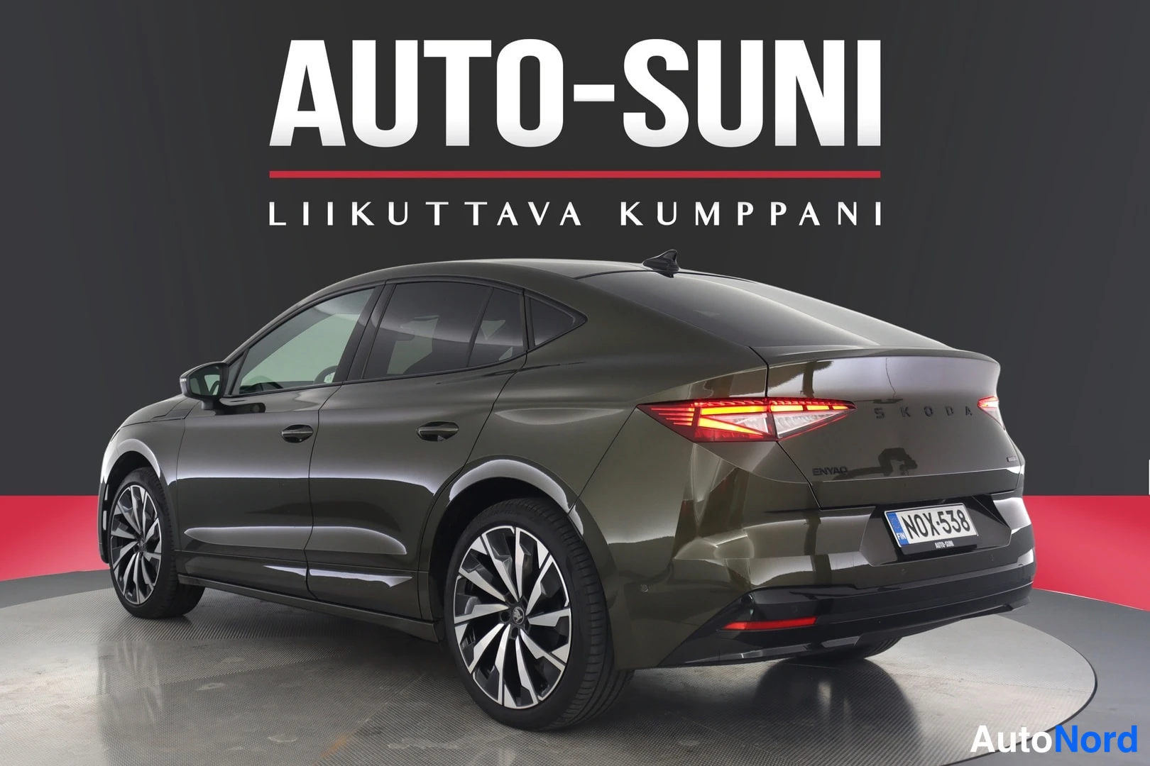 Takaviisto: Auton takanurkkikuva toisesta kulmasta: tummanvihreä Škoda, takavalot, rekisteri ja monisakaraiset kevytmetallivanteet.