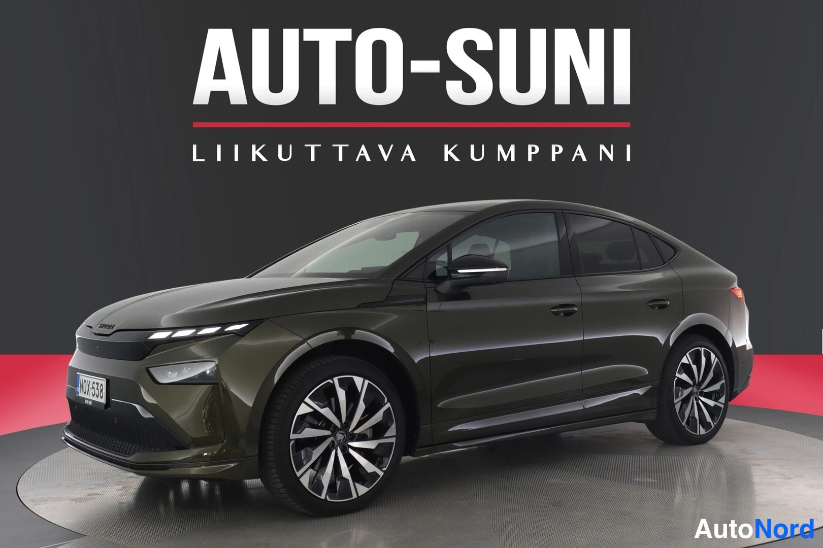 Etuviisto, nokka vasemmalle: Auton etunurkkikuva: tummanvihreä Škoda, ohut DRL-valojana, rekisteri ja suuret kevytmetallivanteet.