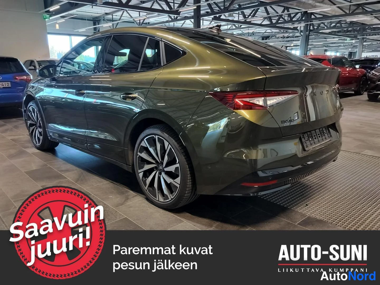 Takaviisto: Takakulmakuva tummanvihreästä Skoda Enyaq Coupé -autosta autosalissa, perävalot ja takapuskuri näkyvissä.