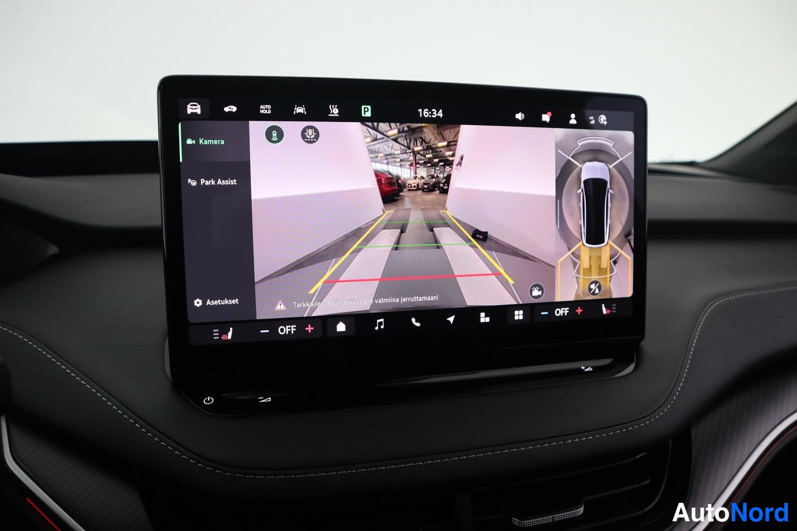 Muu: Kosketusnäyttö näyttää peruutuskameran kuvan ja parkkitilanteen visualisoinnin, tekstit 'Kamera' ja 'Park Assist'.