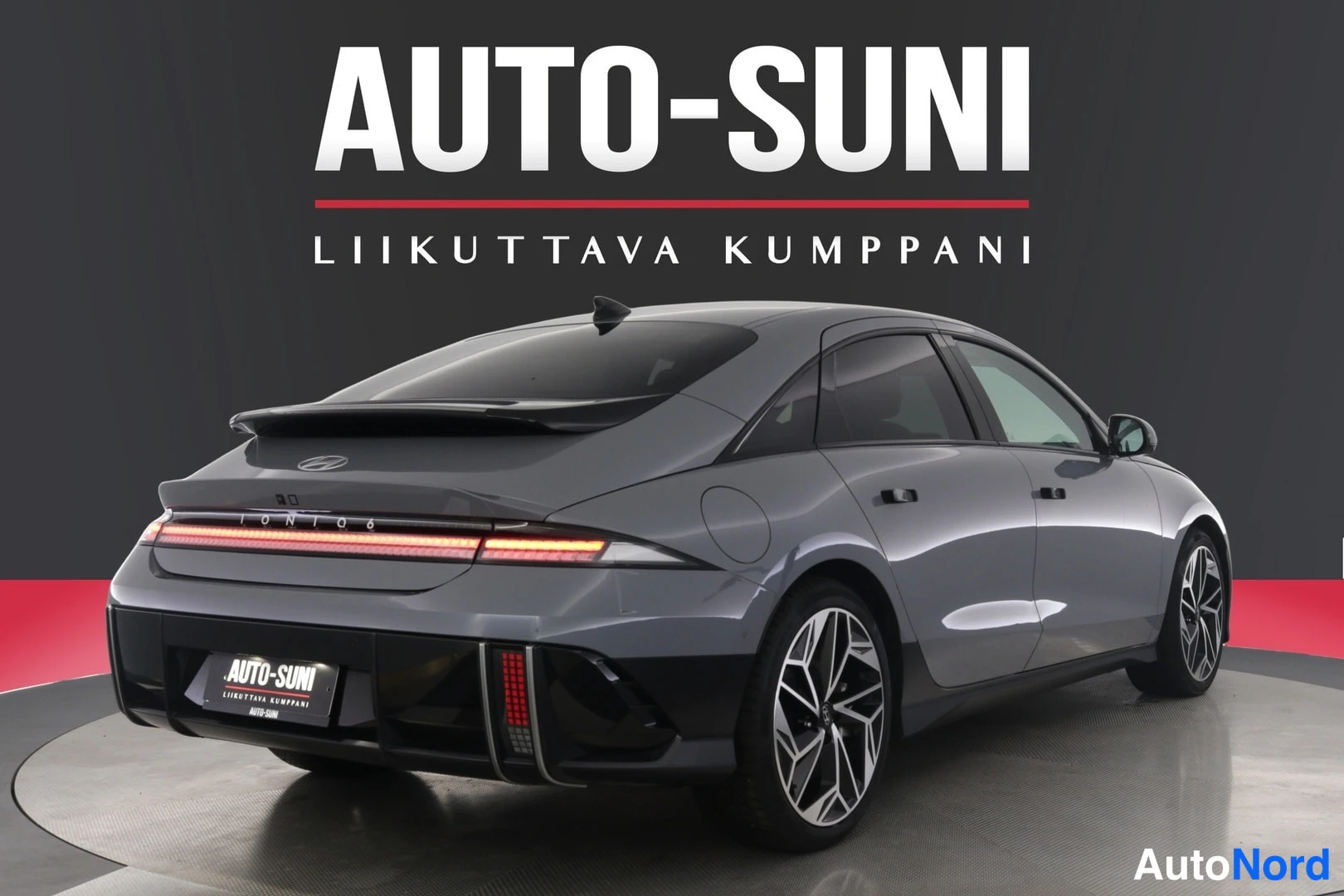 Takaviisto: Hopeanharmaan Hyundai IONIQ 6:n takakulmanäkymä, yläkansi kattava spoileri, poikittainen takavaloreuna ja musta alakolmio.