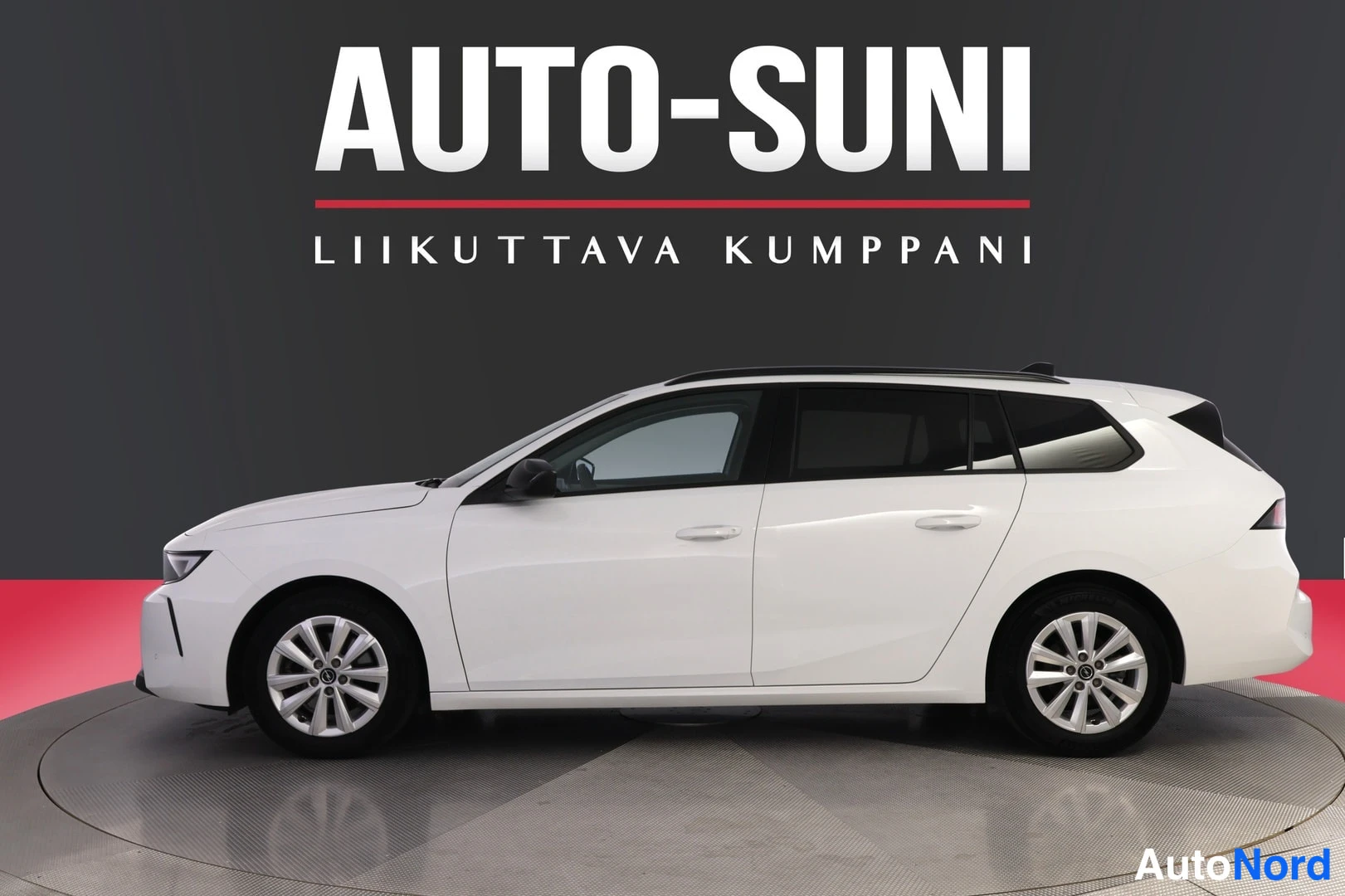 Sivulta: Valkoinen farmariauto sivusta oikea kylki näkyvissä