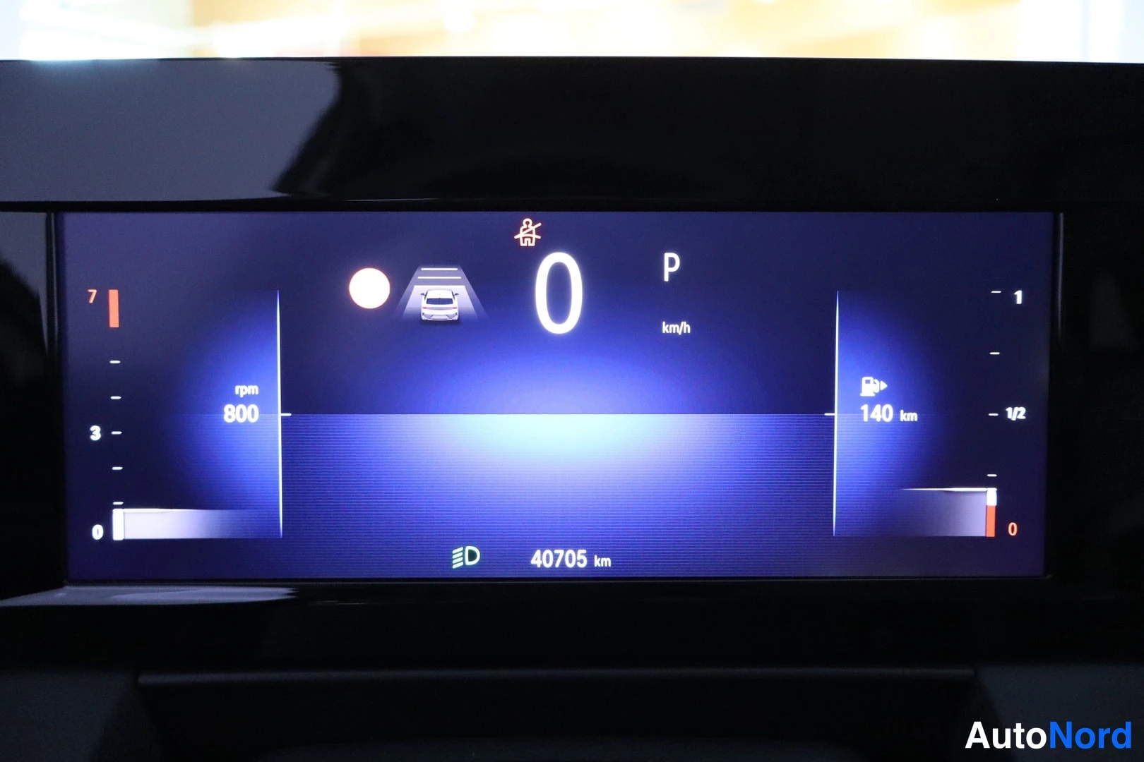 Yksityiskohta: Digitaalinen mittaristo: nopeus 0 km/h, vaihde P, matka-aste 40705 km, päivitetty 140 km, kierrosluku 800 rpm.
