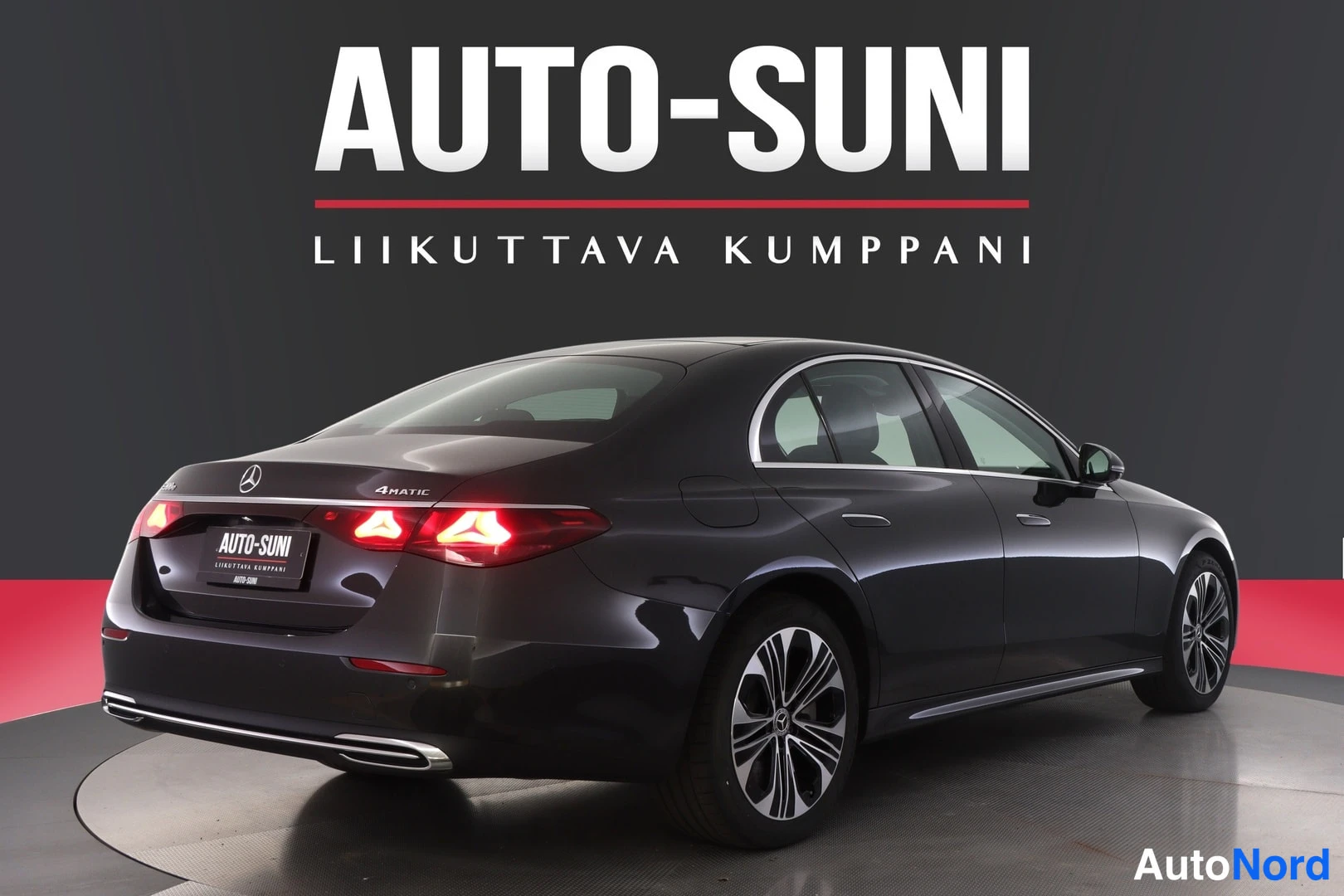 Takaviisto: Tummanharmaa Mercedes-Benz E-sarjan sedan takakulmasta, takavaloja ja konepellin 4MATIC-merkintä näkyvissä.