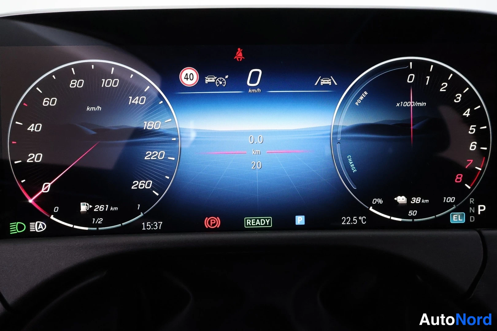 Edestä: Ajoasennossa oleva digitaalinen mittaristo: nopeus 0 km/h, jälellä 261 km, READY-merkinti ja auton lämmityskuva näytöllä.