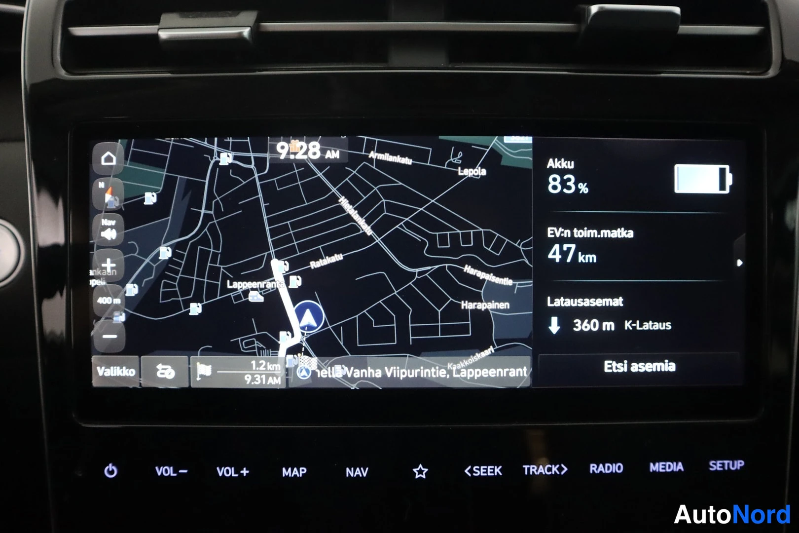 Muu: Auton infotainment-näyttö näyttää karttANavigaatiota, akun varaustasoa 83 % ja sähköllä ajettavaa toimintamatkaa 47 km.