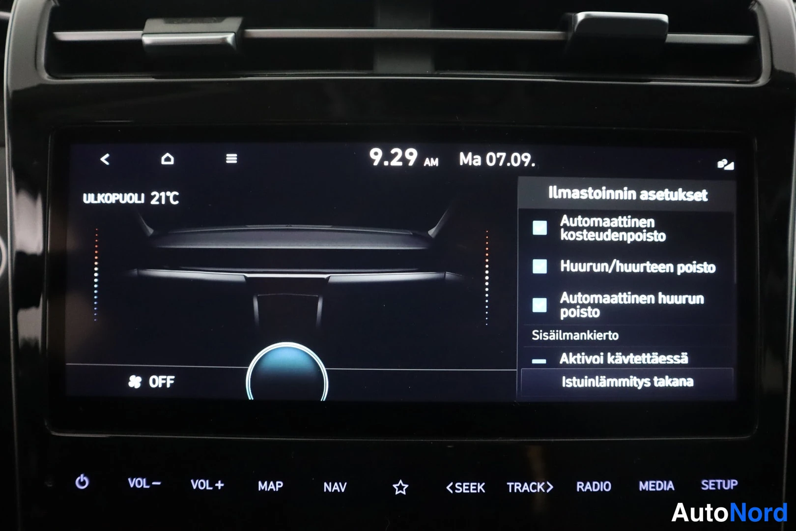 Yksityiskohta: Infotainment-näytön ilmastoinnin asetukset: OFF-tila, ulkolämpötila 21 °C ja alareunan painikkeet kuten MAP, NAV, RADIO ja SETUP.