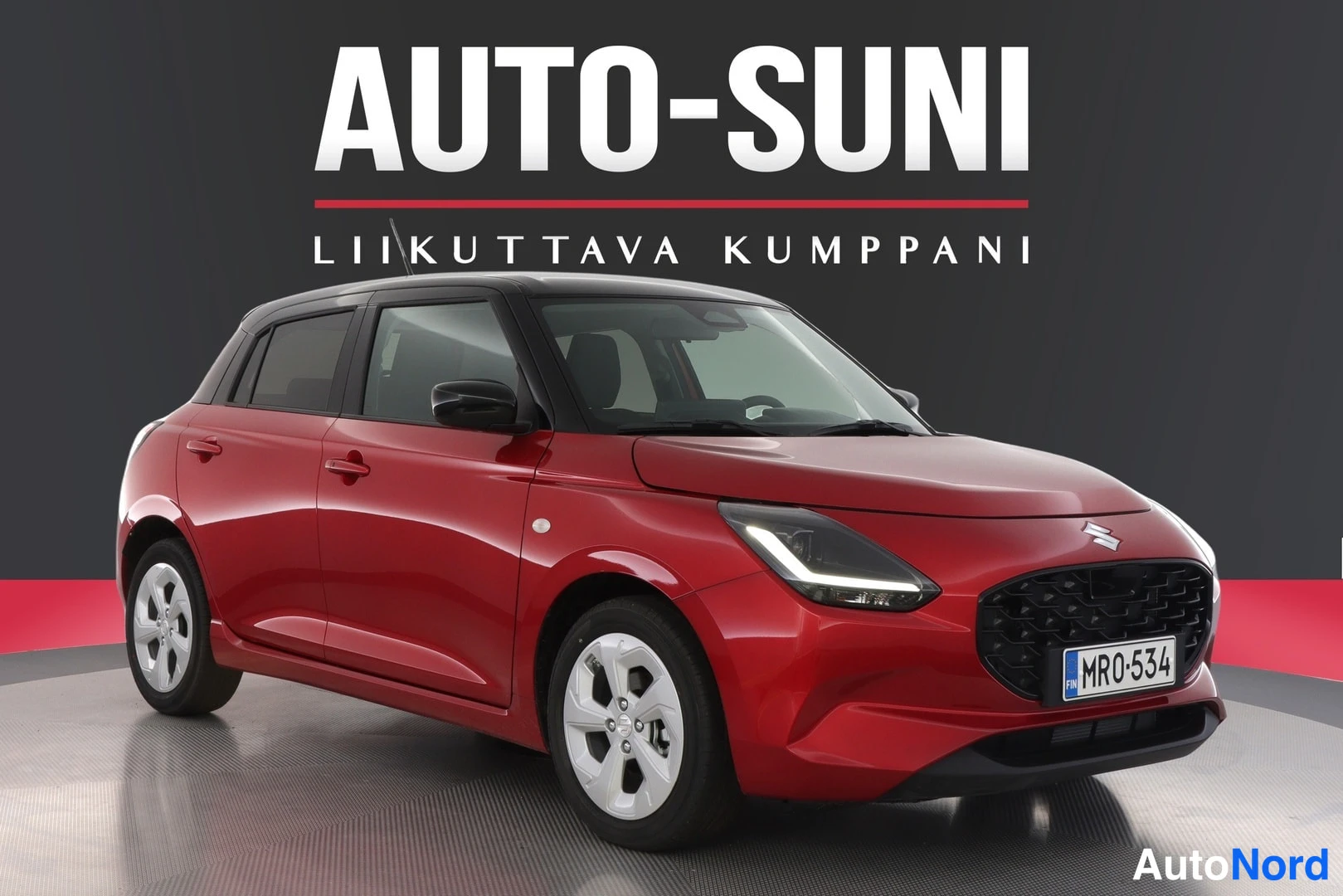 Etuviisto, nokka oikealle: Punainen henkilöauto vinosti edestä oikealta kuvattuna, musta katto ja valkoinen rekisterikilpi MR0-534.