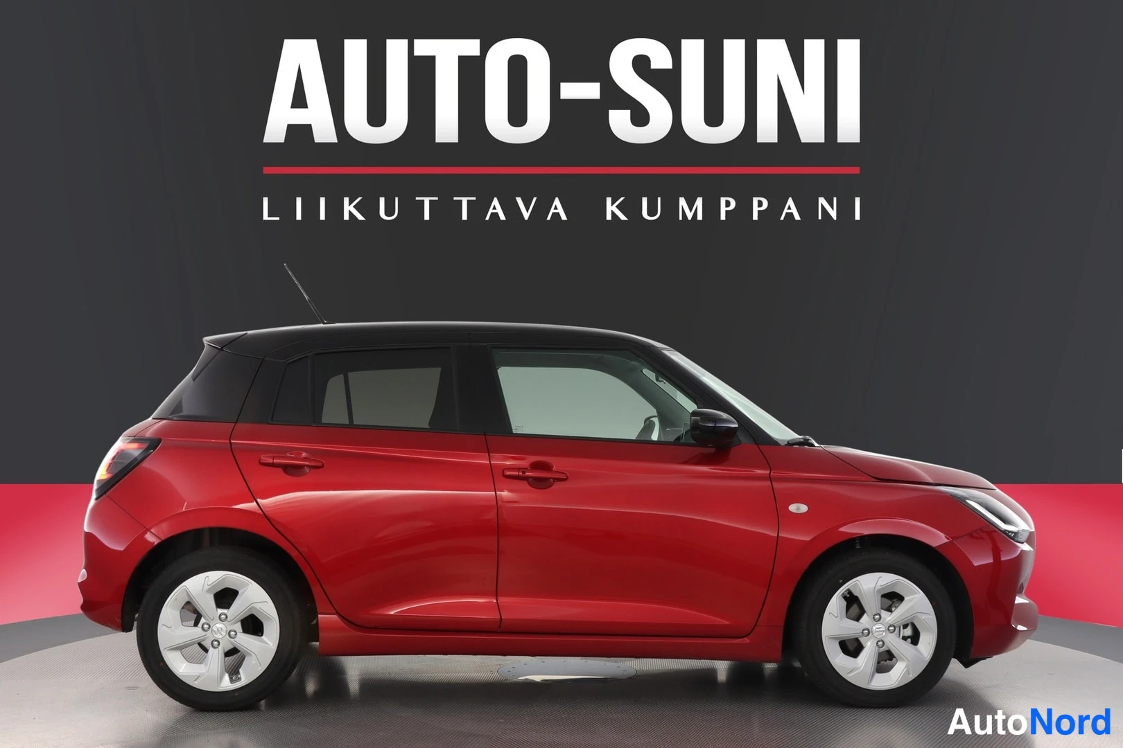 Sivulta: Punainen viisiovinen hatchback sivulta kuvattuna, musta katto ja hopeiset pyörät.