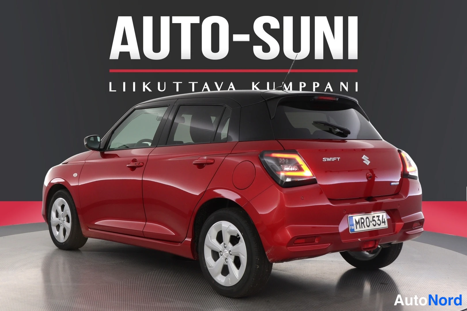 Takaviisto: Punaisen hatchbackin takaosa ja vasen kylki vinosta takaa kuvattuna, musta katto, rekisterikilpi MR0-534 ja SWIFT-teksti takaluukussa.