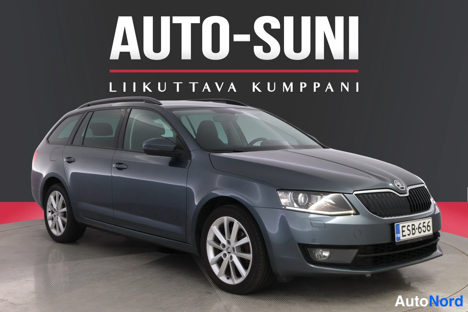 Etuviisto, nokka oikealle: Sinertävän harmaa Skoda Octavia -farmari kolmesta neljäsosasta edestä oikealta, rekisterikilpi.