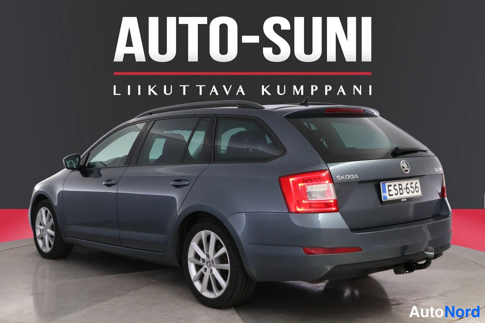 Takaviisto: Sinertävän harmaa Skoda Octavia -farmari kolmesta neljäsosasta takaa oikealta, rekisterikilpi, SKODA-teksti takaluukussa.