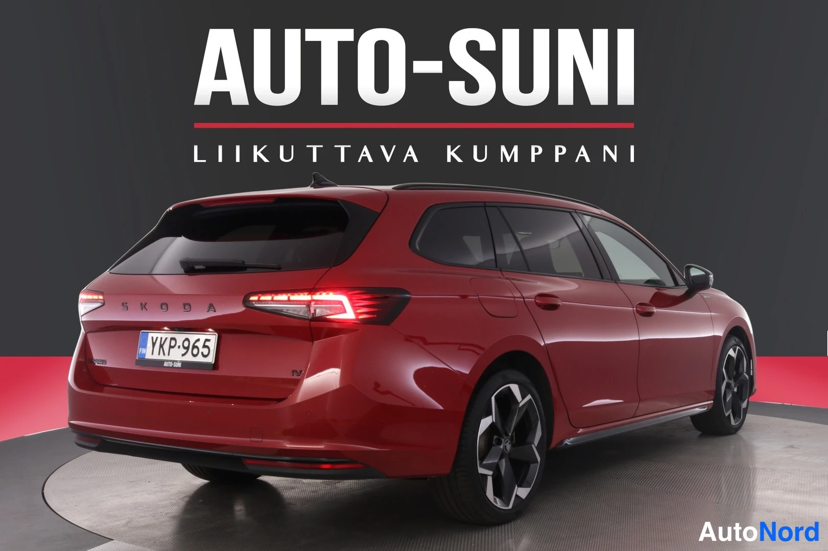 Takaviisto: Punaisen farmariauton takapää ja kylki studiossa, rekisteritunnus.