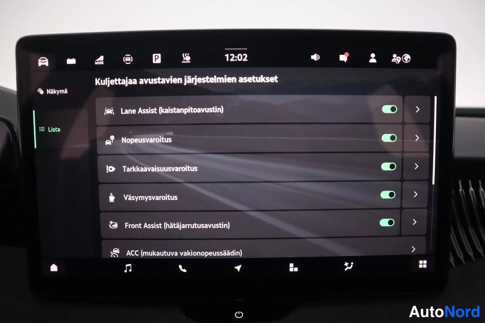 Yksityiskohta: Auton infotainment-näyttö näyttää kuljettajan avustavien järjestelmien asetukset. Listalla ovat Lane Assist (kaistanpitoavustin), Nopeusvaroitus, Tarkkaavaisuus