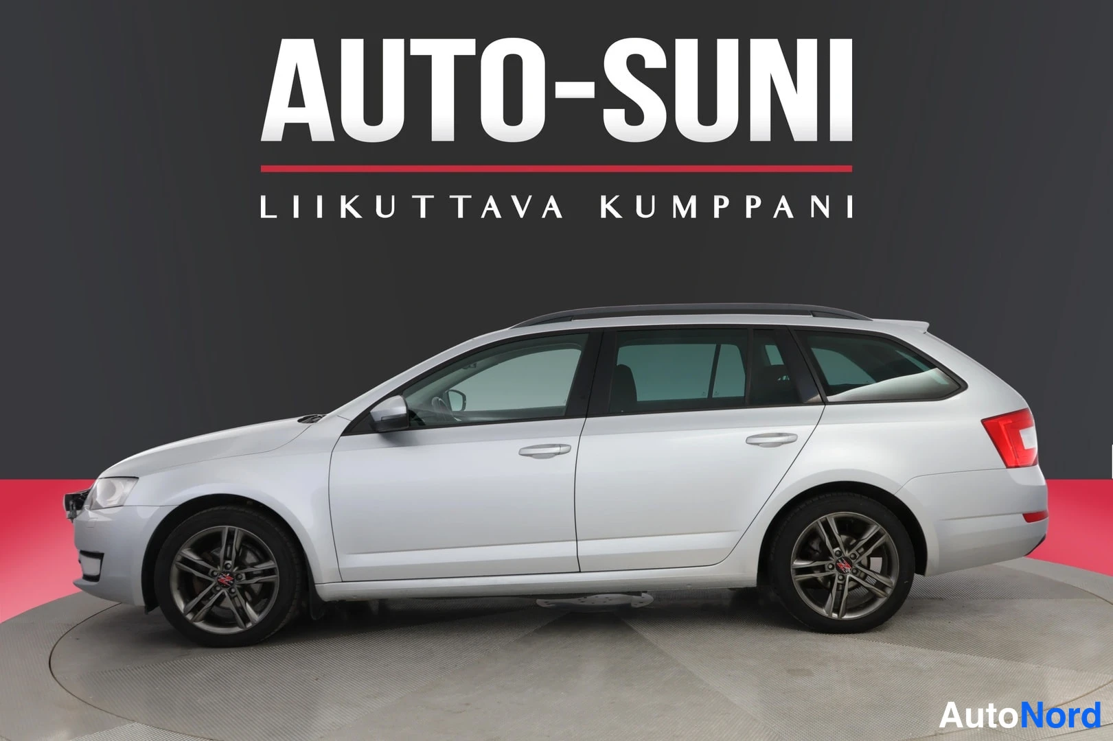 Sivulta: Hopeanvärinen farmariauto kuvattu sivusuunnasta etukolmasosa vasemmalla, studio-tumma tausta, kuvateksti AUTO-SUNI, LIIKUTTAVA KUMPPANI.