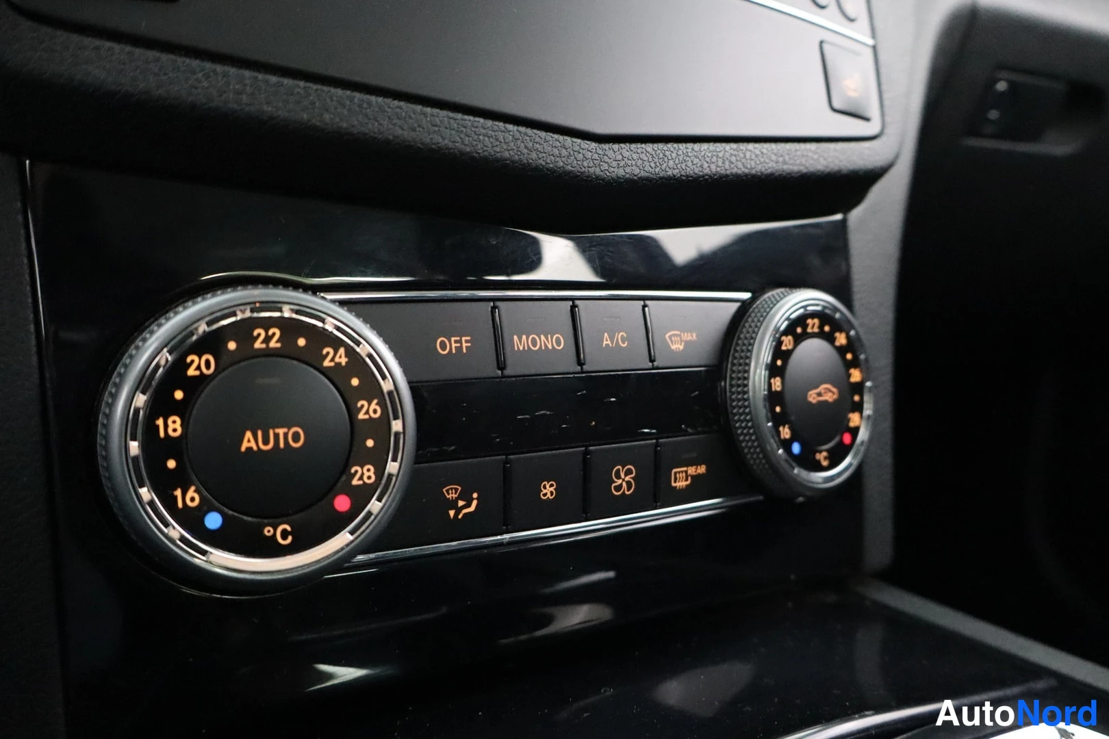 Edestä: Automaattisen kaksivyöhykeilmastoinnin paneeli: AUTO- ja lämpötilanupit (16–28 °C), painikkeet OFF, MONO, A/C ja MAX sekä takalasin lämmityspainike.