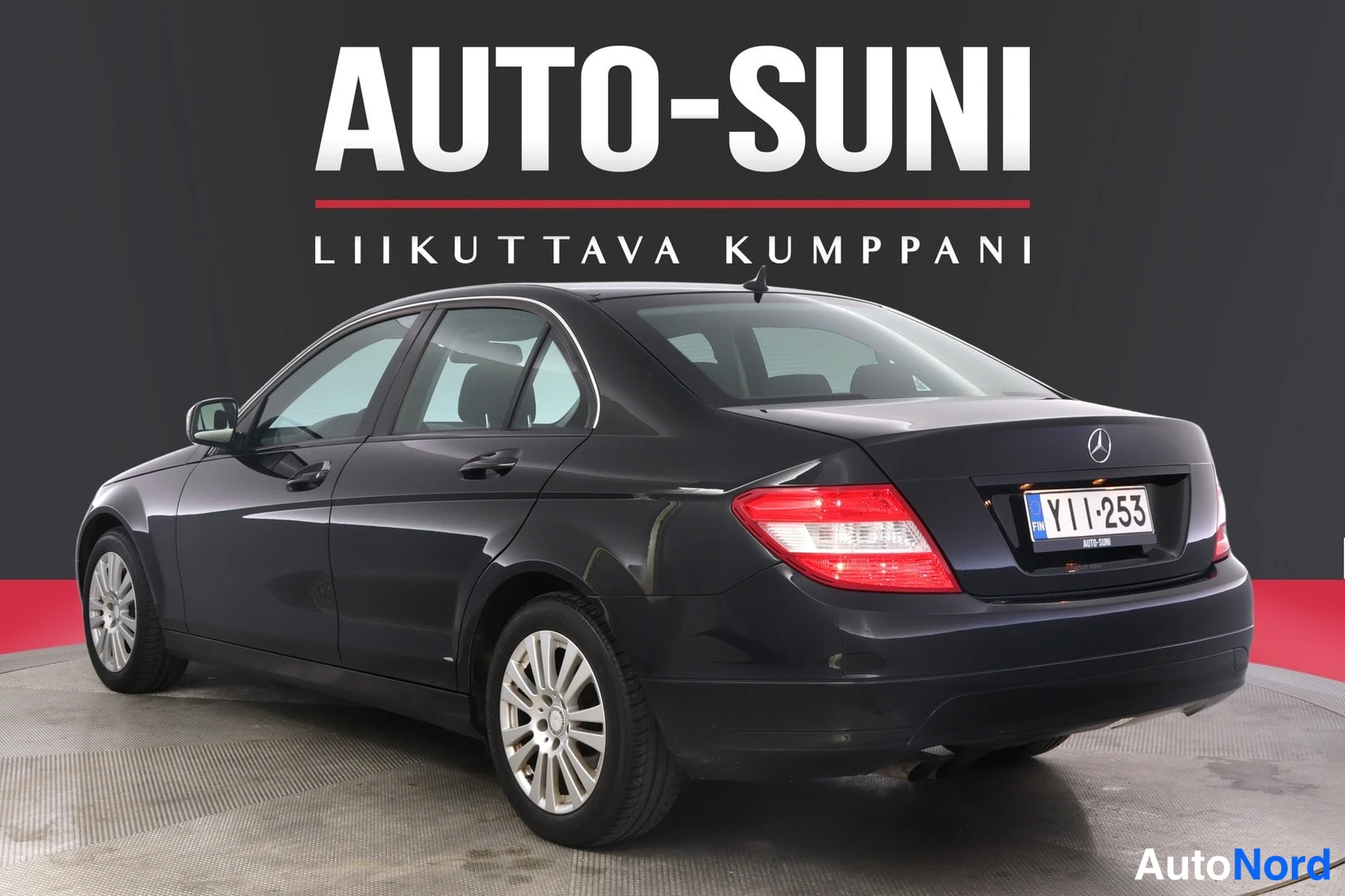 Takaviisto: Mustan Mercedes-Benz C 2008 -henkilöauton takakulmakuva vasemmalta, rekisterikilpi YI I-253, studiotauustaa vasten.