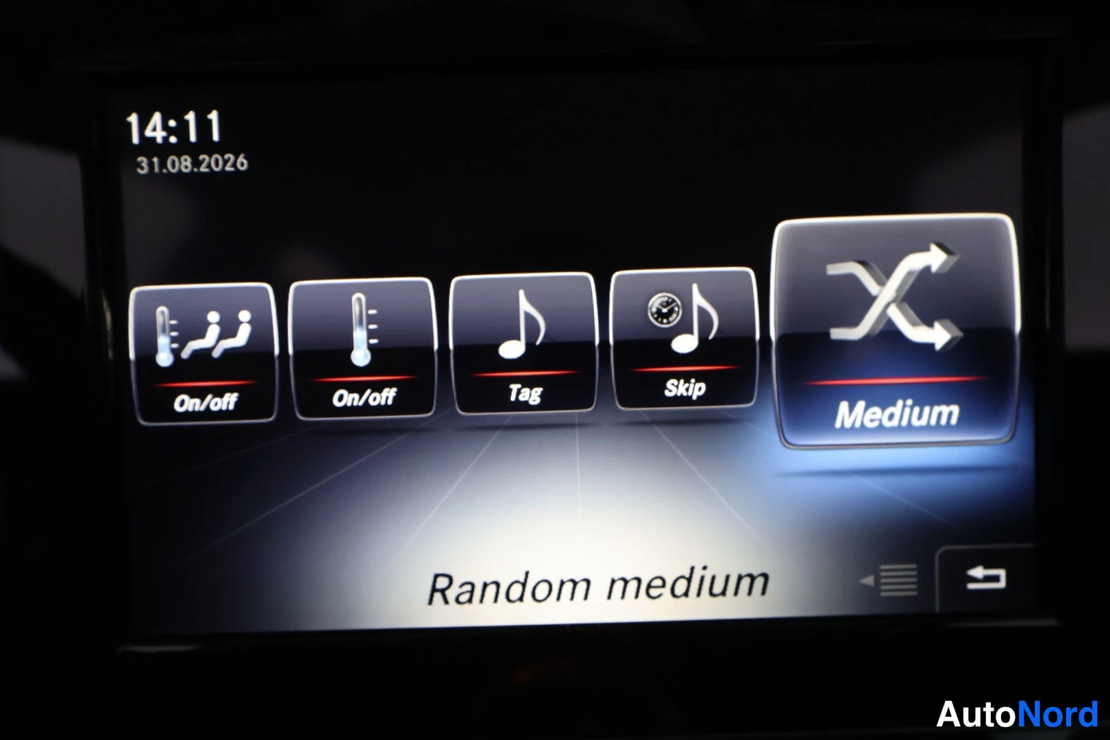 Muu: Mercedes-Benzin infotainment-näytön infotainment-näytön kuva: näytöllä näkyy 14:11, 31.08.2026 ja valikko On/off, On/off, Tag, Skip, Medium, tekstinä Random med