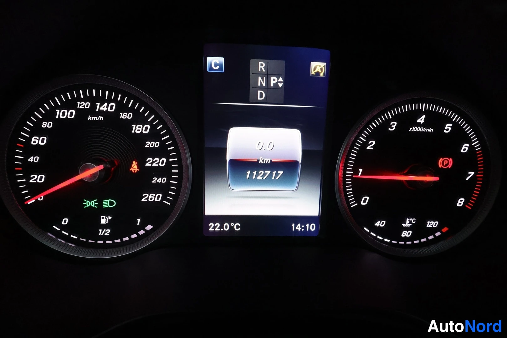 Muu: Kojelaudan näyttö, joka näyttää P-vaihteen, km-lukeman 112717, lämpötilan 22.0 °C ja kellonajan 14:10.