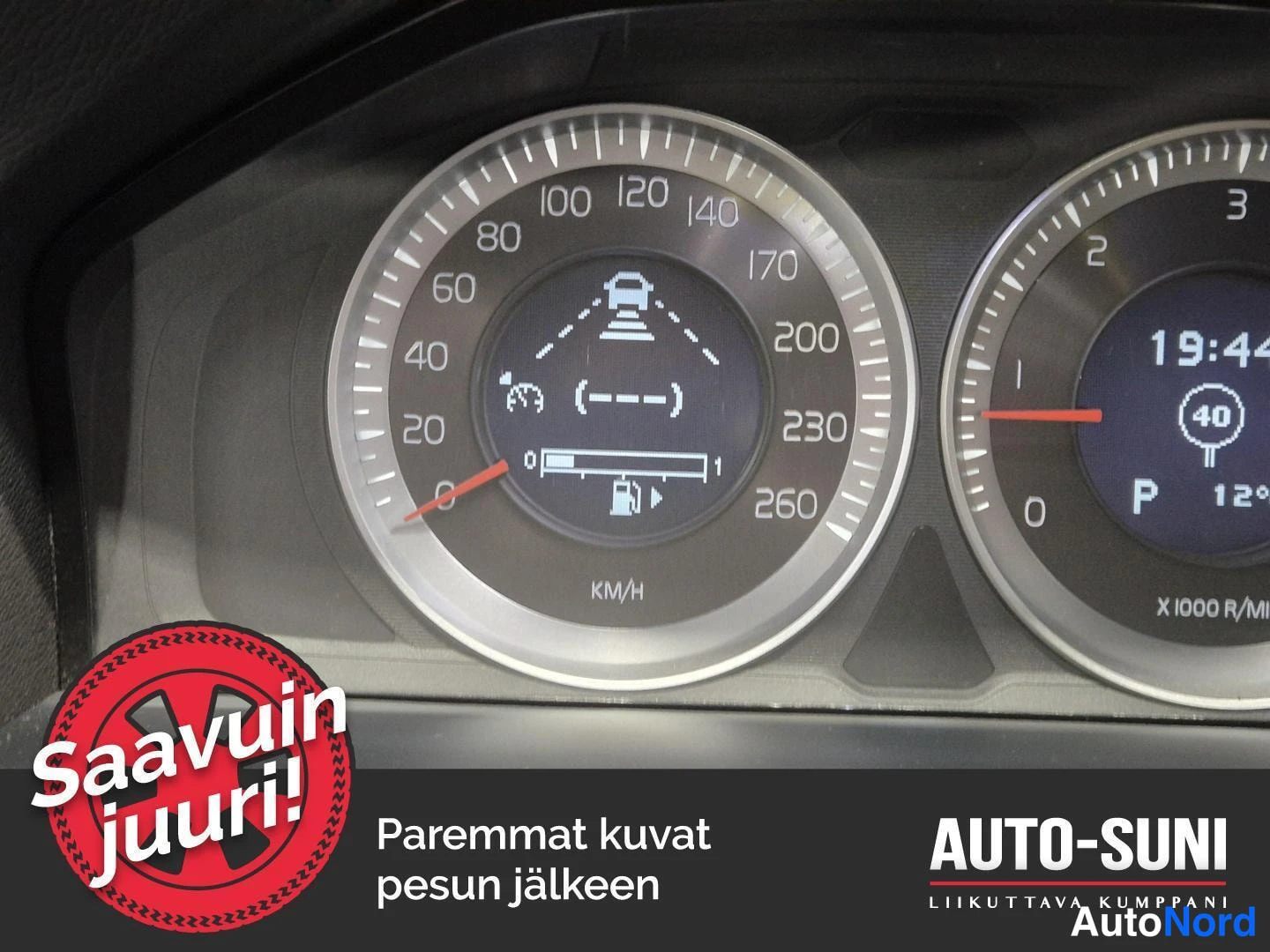 Muu: Kojelaudan nopeusmittari lähikuvassa: nuoli osoittaa 0 km/h, polttoainemittari noin neljännes täynnä, ajoneuvon kaista-avustajan symboli mittarin keskellä; kell