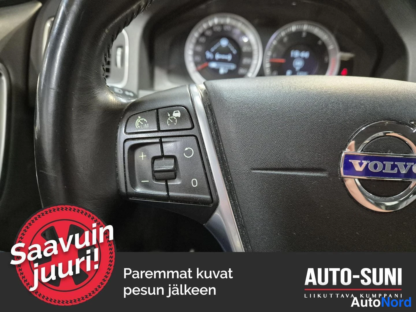Muu: Ohjauspyörän vasen puoli lähikuvassa: raitisilmasuodattimen ja nopeudensäädön merkit ohjauspyörän vasemmassa puhelinpaneelissa, Volvo-logo sinitekstisinä painik
