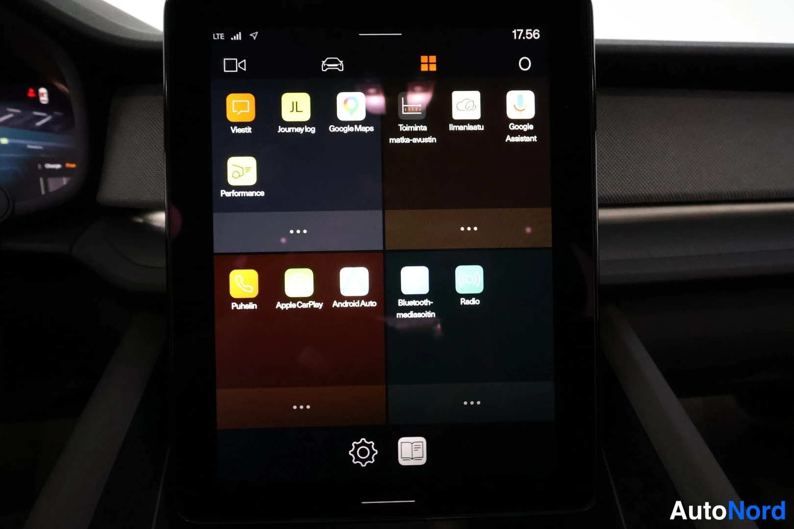 Yksityiskohta: Keskirivin kosketusnäytön sovellusruutu lähikuvassa: sovelluskortit kuten Apple CarPlay, Android Auto, Puhelin, Radio, Google Maps ja Google Assistant; aikana n