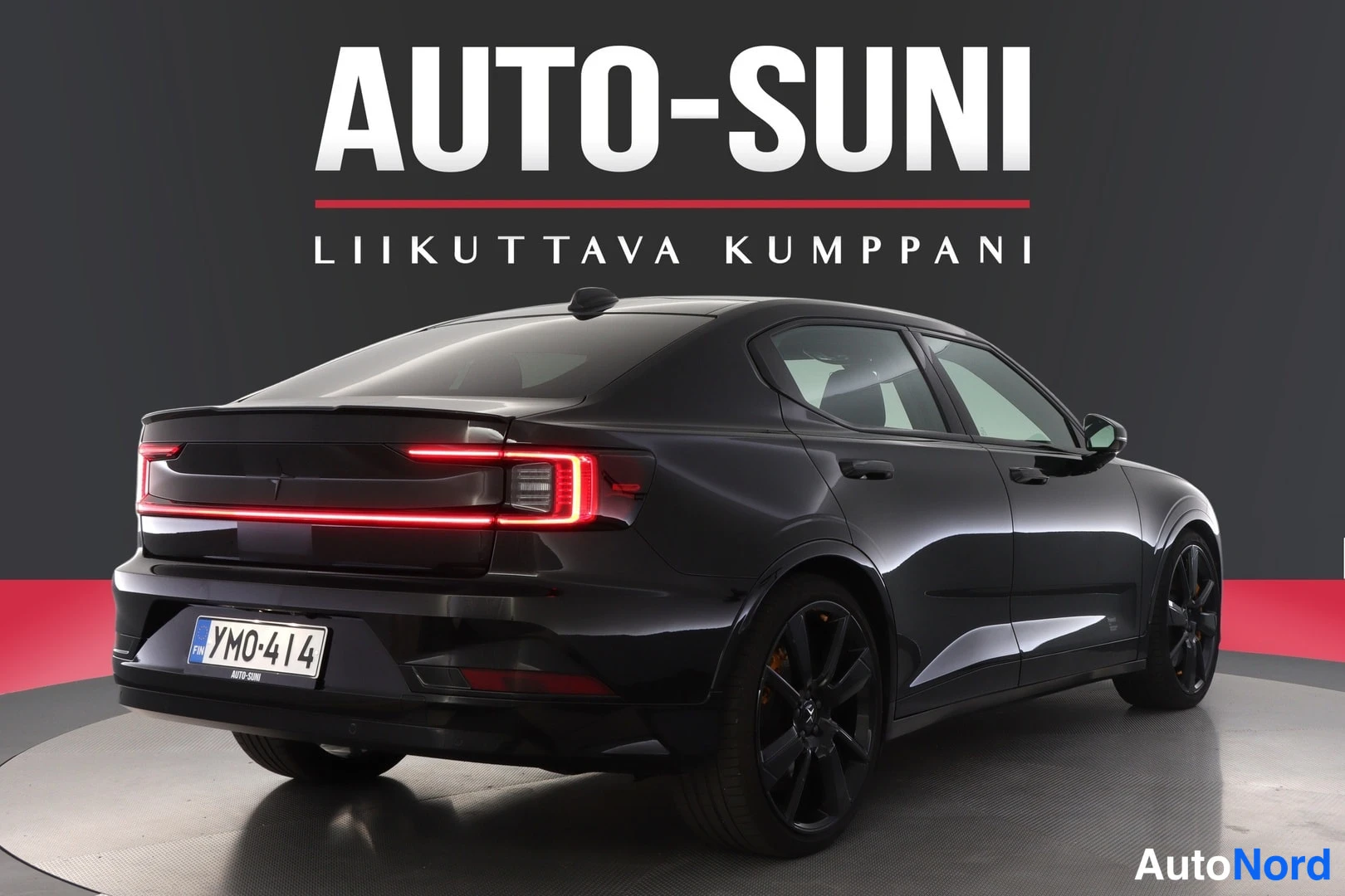 Takaviisto: Autosuni-studio: mustan sedanin takakulma, punainen poikittainen takavalosarja, rekisteri.