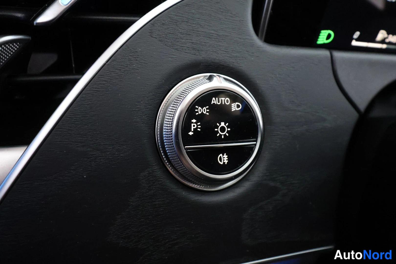 Yksityiskohta: Auton kojelaudan valokytkin, jonka asennot AUTO, lyhdyt ja sumuvalo ovat merkittyinä.