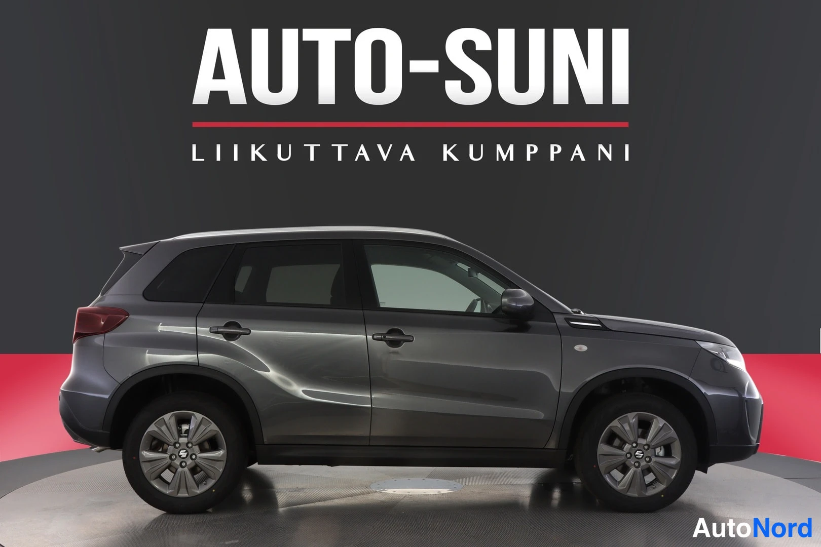 Sivulta: Auton sivuprofiili vasemmalta, tummansininen metallic, kattoharjoja ja kesärenkaat