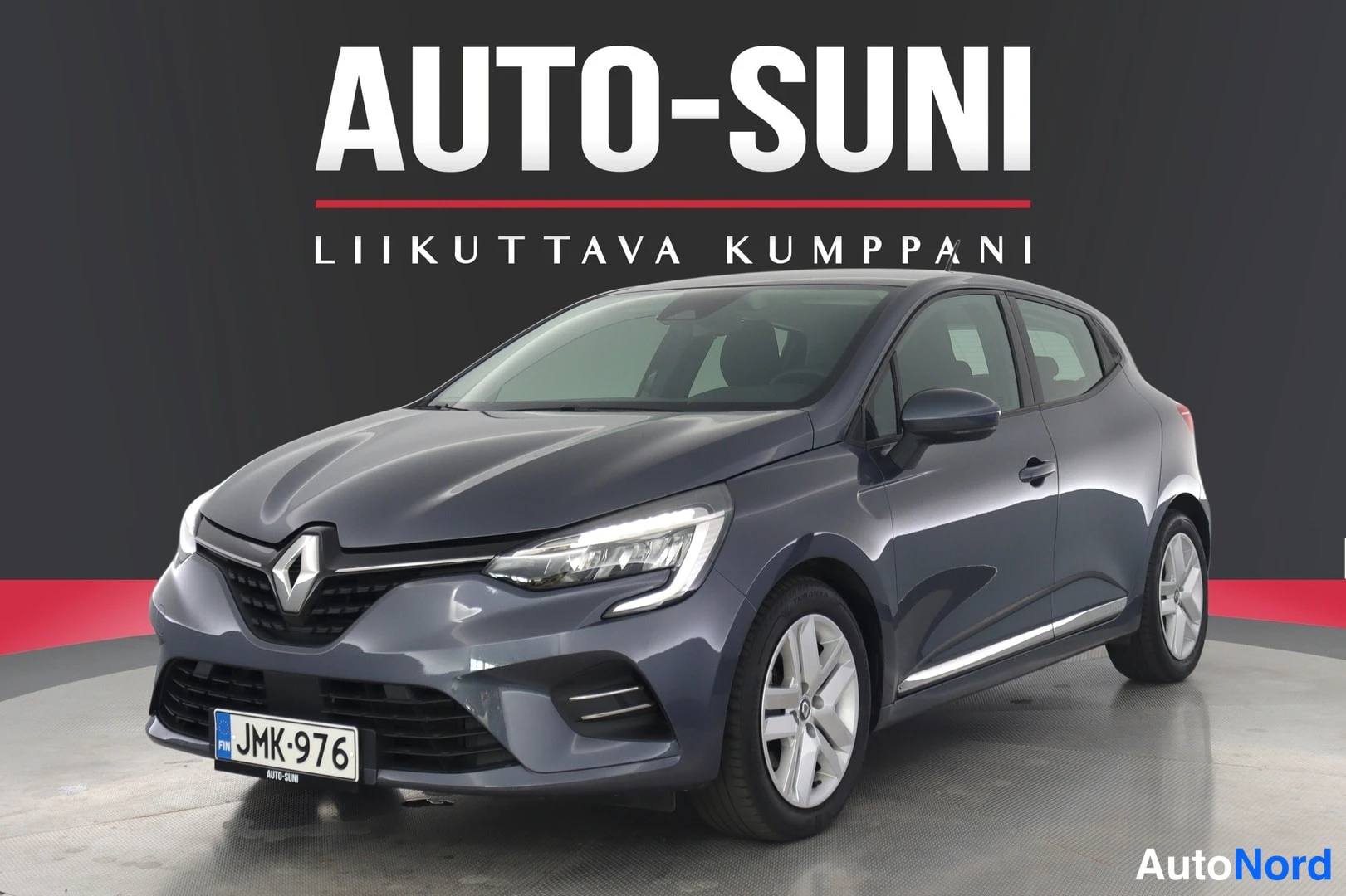Etuviisto, nokka vasemmalle: Sama sinertävän harmaa hatchback kuvattuna lähempää edestä vasemmalta, rekisterikilpi näkyvissä.