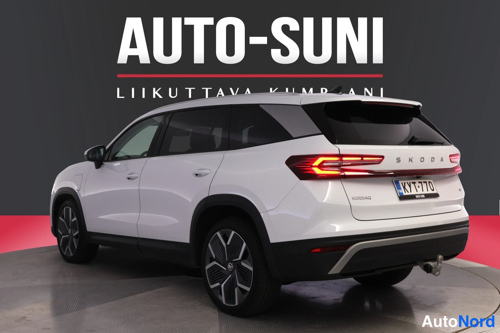 Takaviisto: Rear three-quarter view of a white Skoda Kodiaq with illuminated LED taillights.
