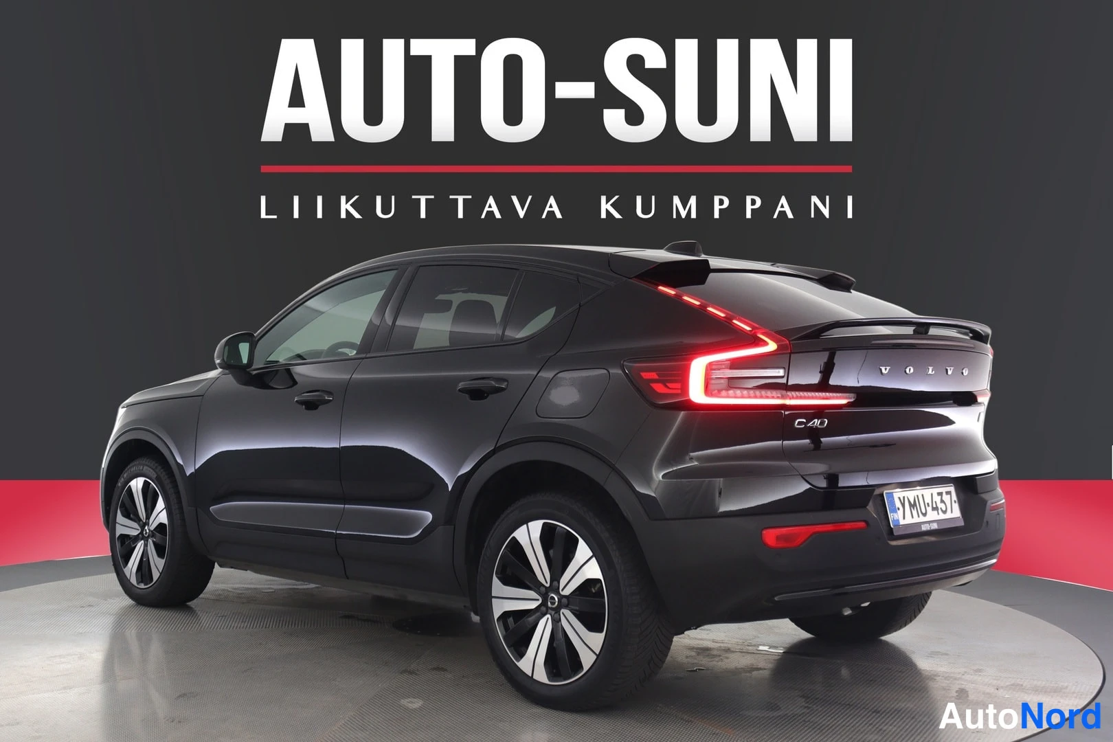 Takaviisto: Mustan henkilöauton takaosa ja oikea kylki, takavalot syttyneinä, C40-merkintä takaluukussa.