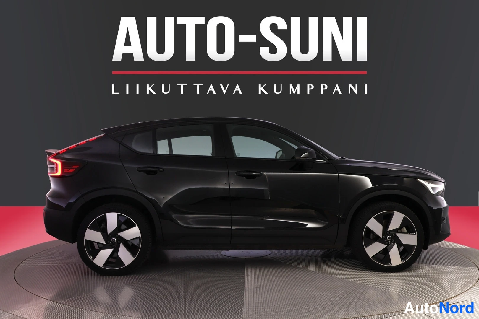 Sivulta: Musta Volvo C40 sivulta, kokonainen oikea kylki ja pyörät näkyvissä.