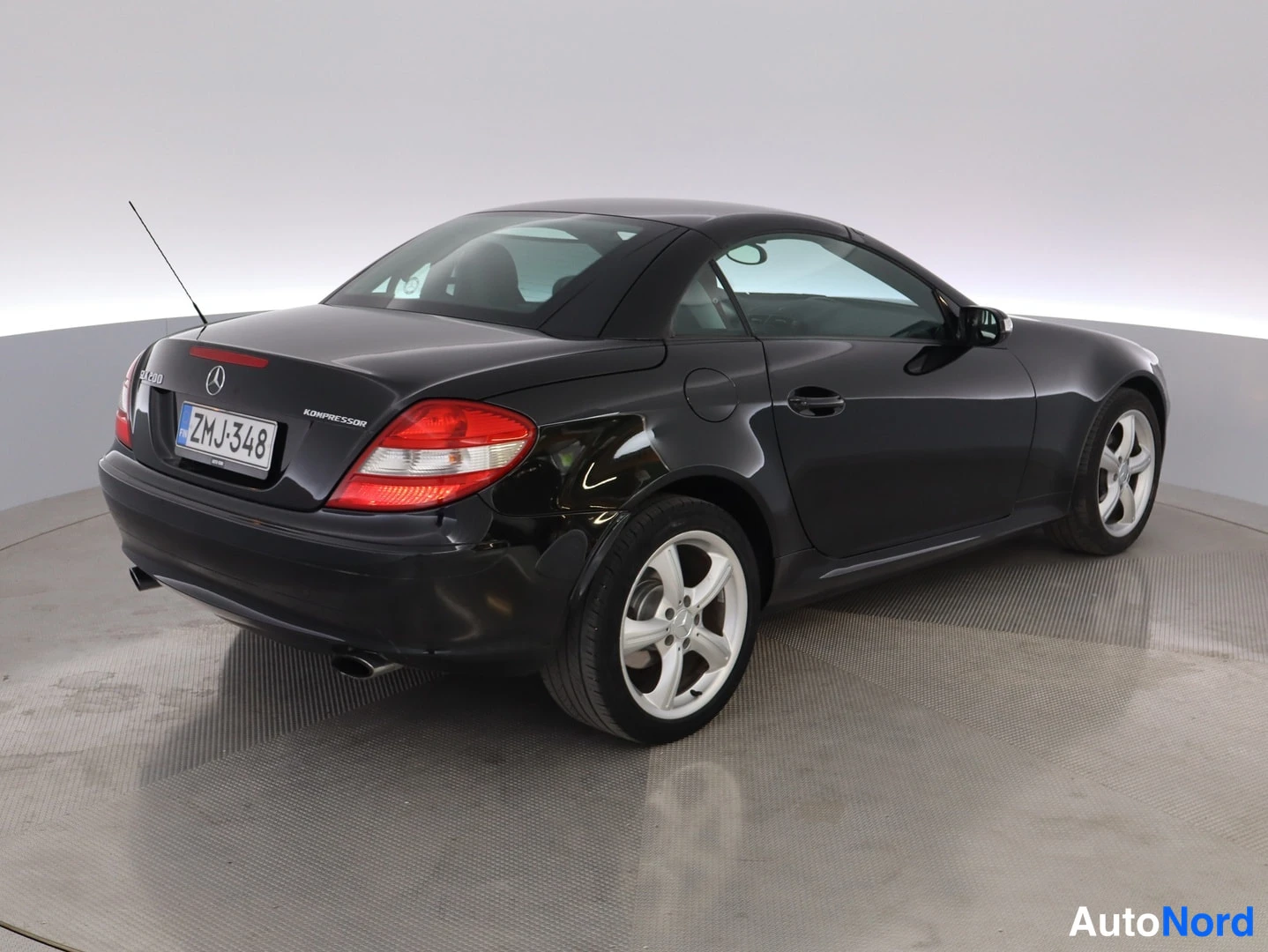 Takaviisto: Mustan Mercedes-Benz SLK:n takaosa ja kylki kolmannesvaistosta, rekisterikilpi