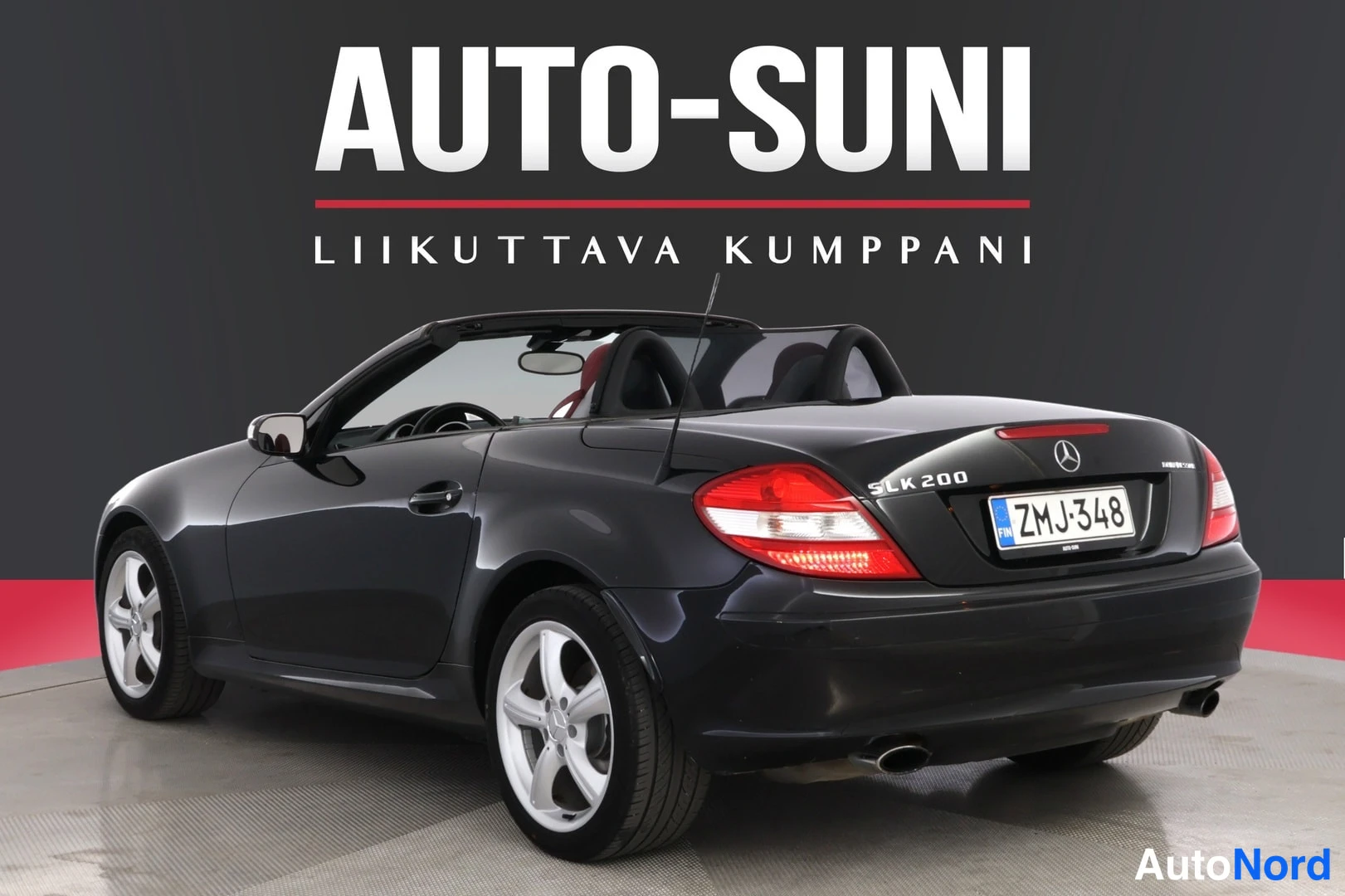 Takaviisto: Musta Mercedes-Benz SLK takaa vasemmalta kuvattuna, rekisterikilpi, katto auki.