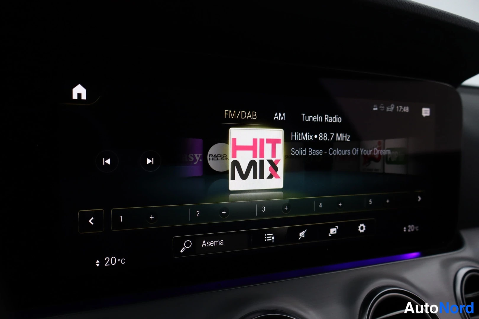 Muu: Auton kojelaudan multimedianäyttö, jossa radion valikko: FM/DAB, AM ja TuneIn Radio, kanava HitMix 88.7 MHz, asemapainikkeet 1–5, lämpötila 20 °C ja kello 17:48