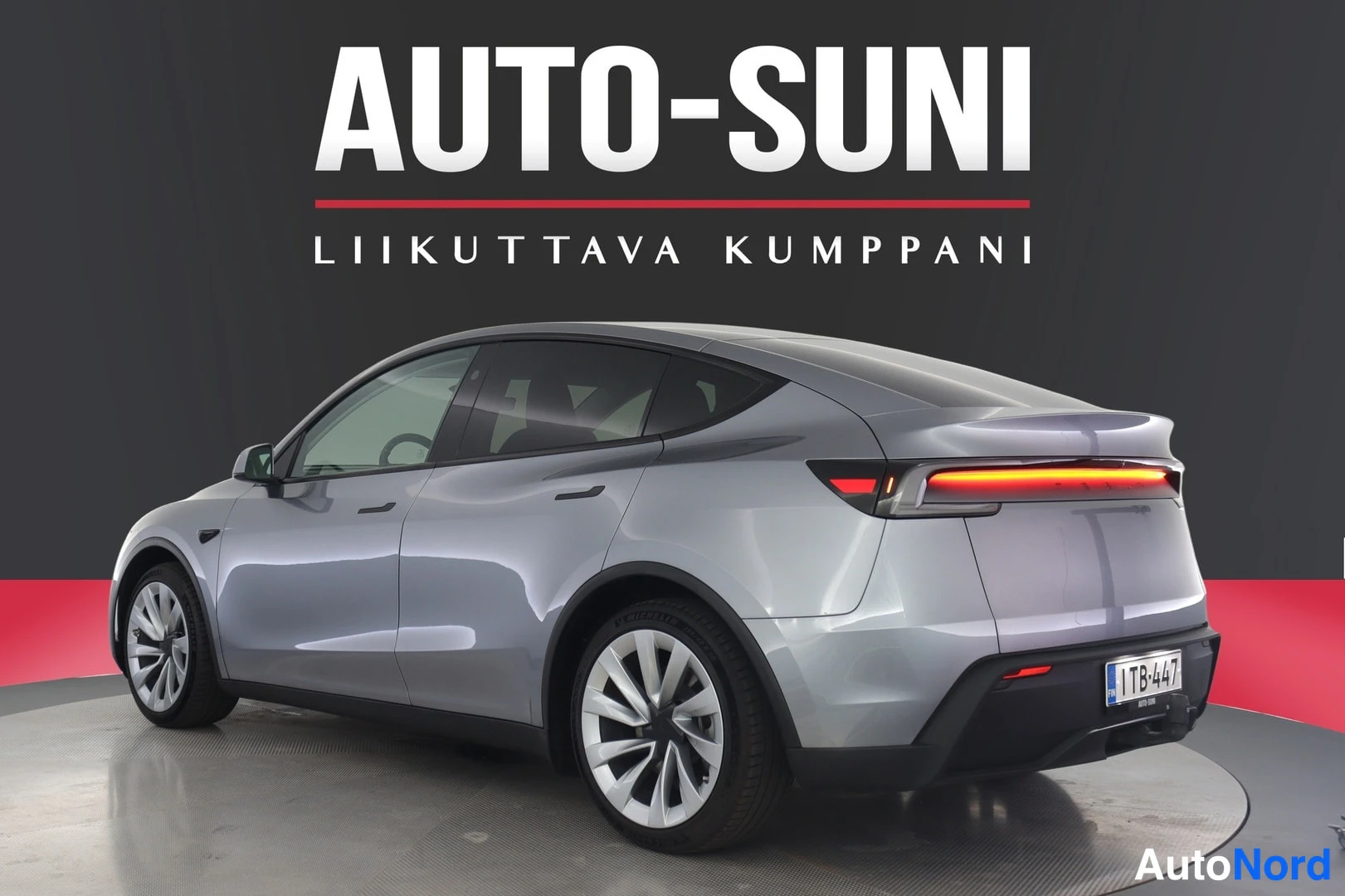 Takaviisto: Hopeanharmaa Tesla Model Y takakulmakuvassa oikealta sivulta, rekisterikilpi