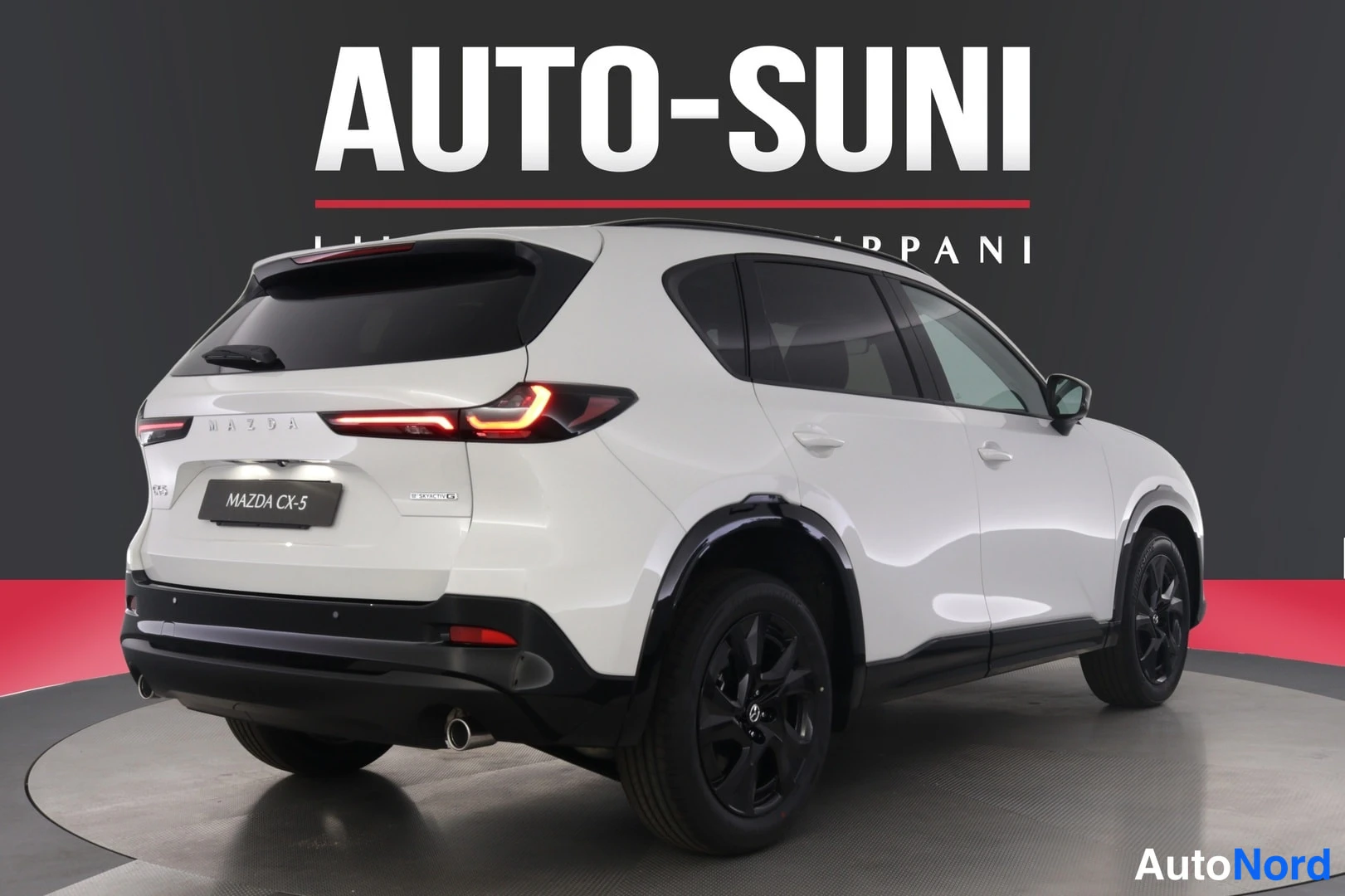 Takaviisto: Valkoisen SUV-auton takakolmasnäkymä: ohut LED-takavalot, kattospoileri, kromattu pakoputki ja mustat vanteet.