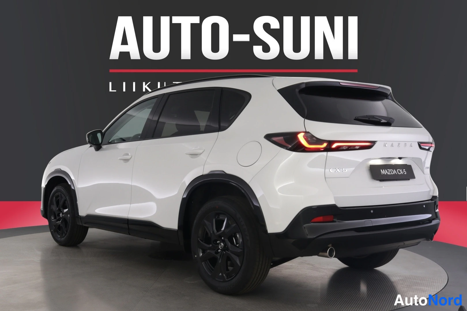 Takaviisto: Valkoisen SUV-auton taka- ja kylkinäkymä oikealta: takavalot, CX-5-merkintä kannessa, mustat vanteet ja kattokaiteet.