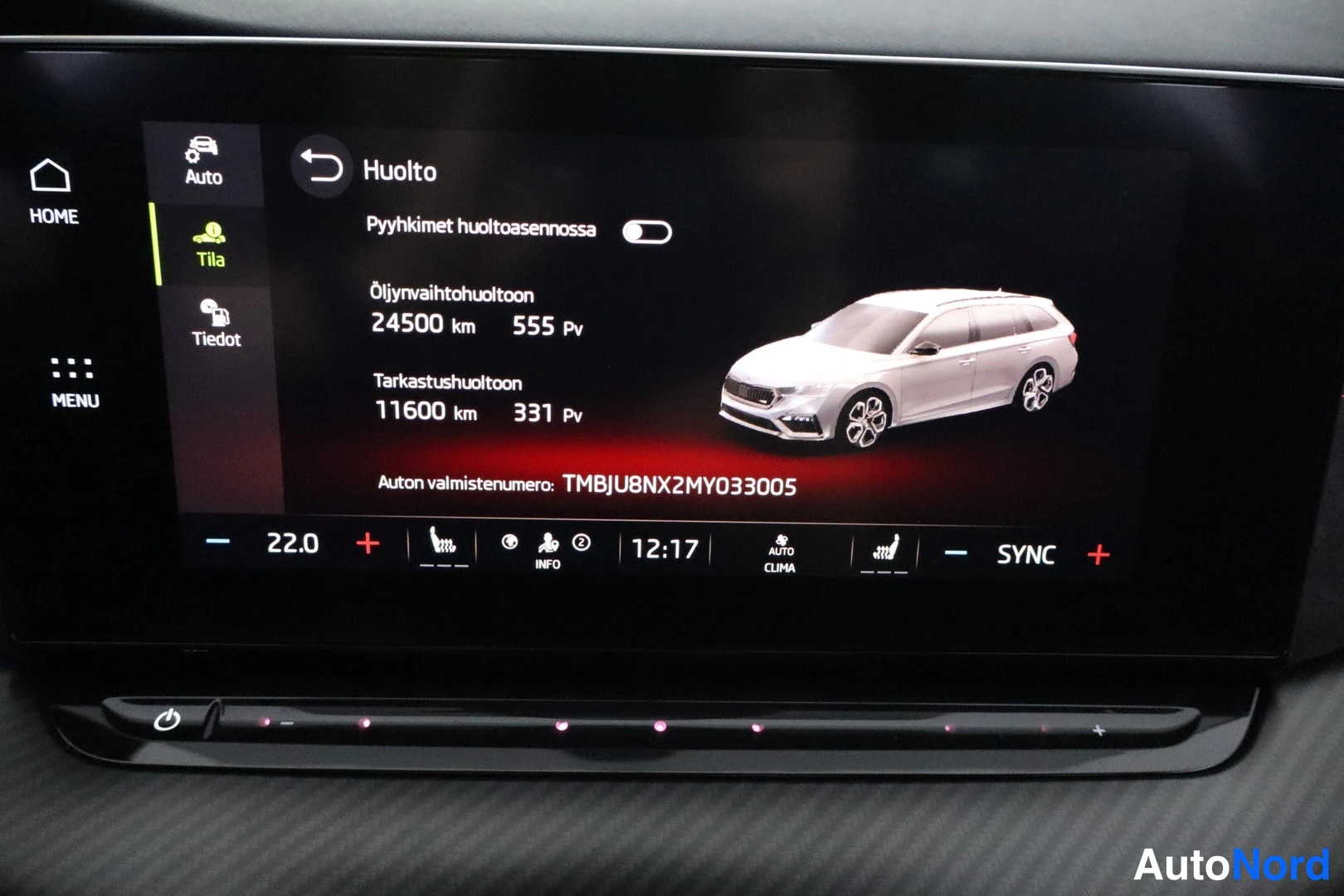 Edestä: Infotainment-näyttö Huolto-valikossa, jossa näkyy huoltovälit 24500 km / 555 pv ja 11600 km / 331 pv, auton valmistenumero TMBJU8NX2MY033005 sekä alareunassa lä