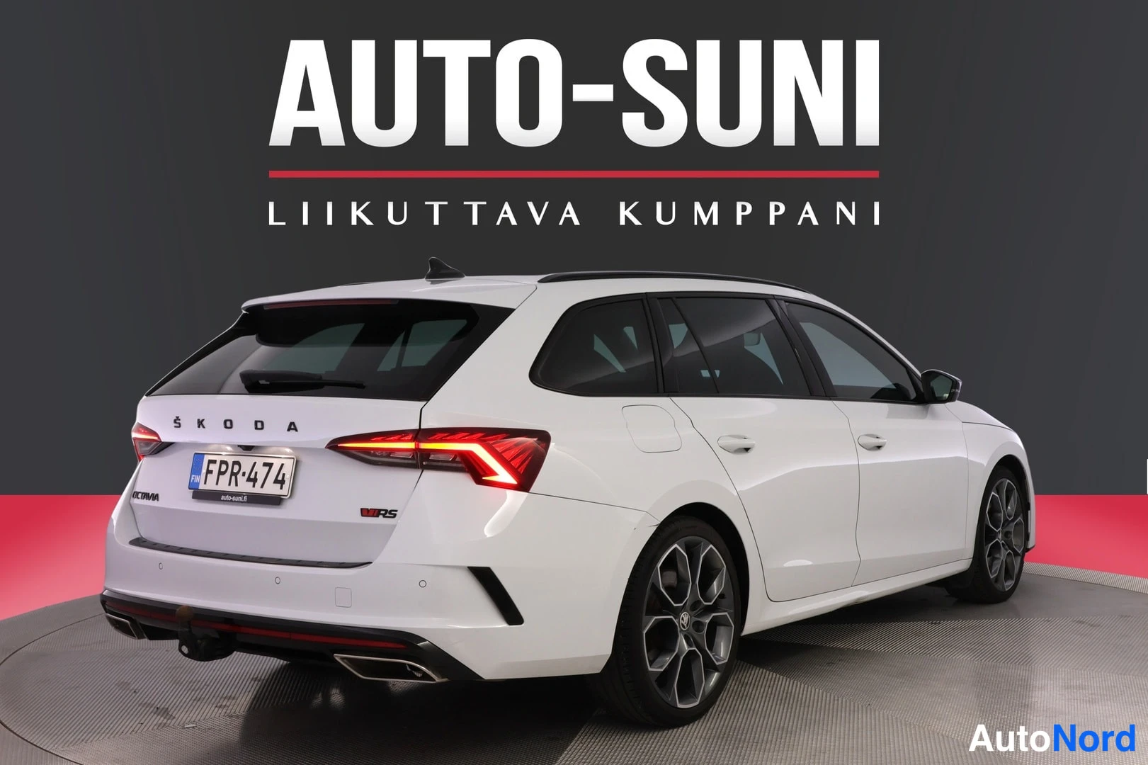 Takaviisto: Valkoisen farmariauton takaosa vasemmasta kulmasta, takavalot ja ŠKODA-teksti, rekisterikilpi.