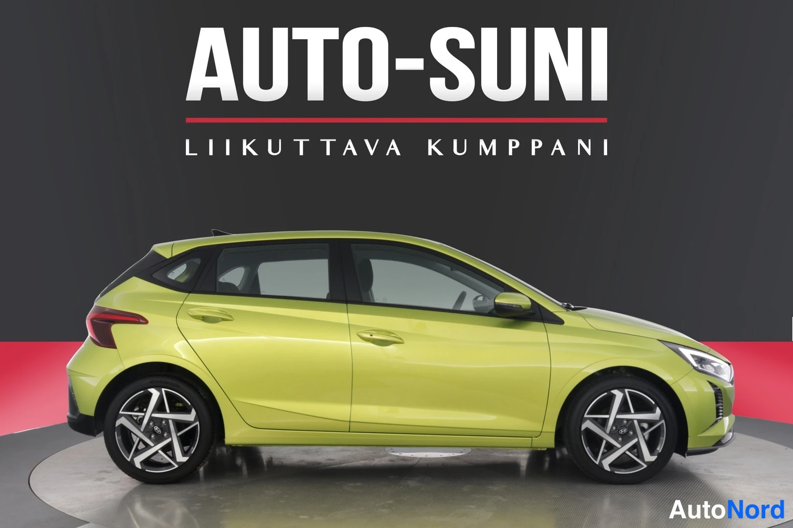 Sivulta: Vihränkeltainen Hyundai i20 -viistotakaa vasemmalta sivulta, koko auton kylki studiotaustaa vasten.