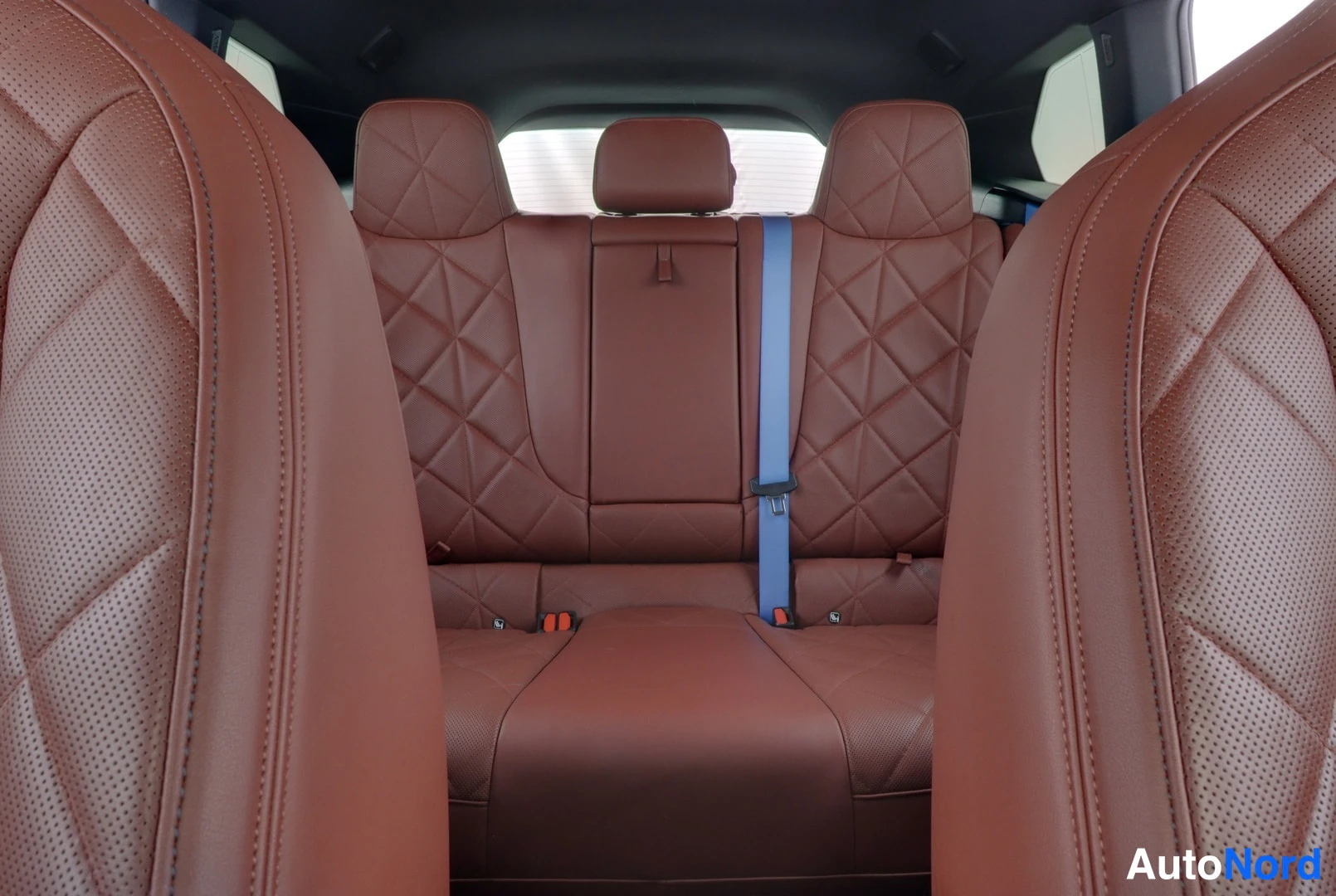 Takaistuimet: Rear interior view showing brown leather bench seat.
