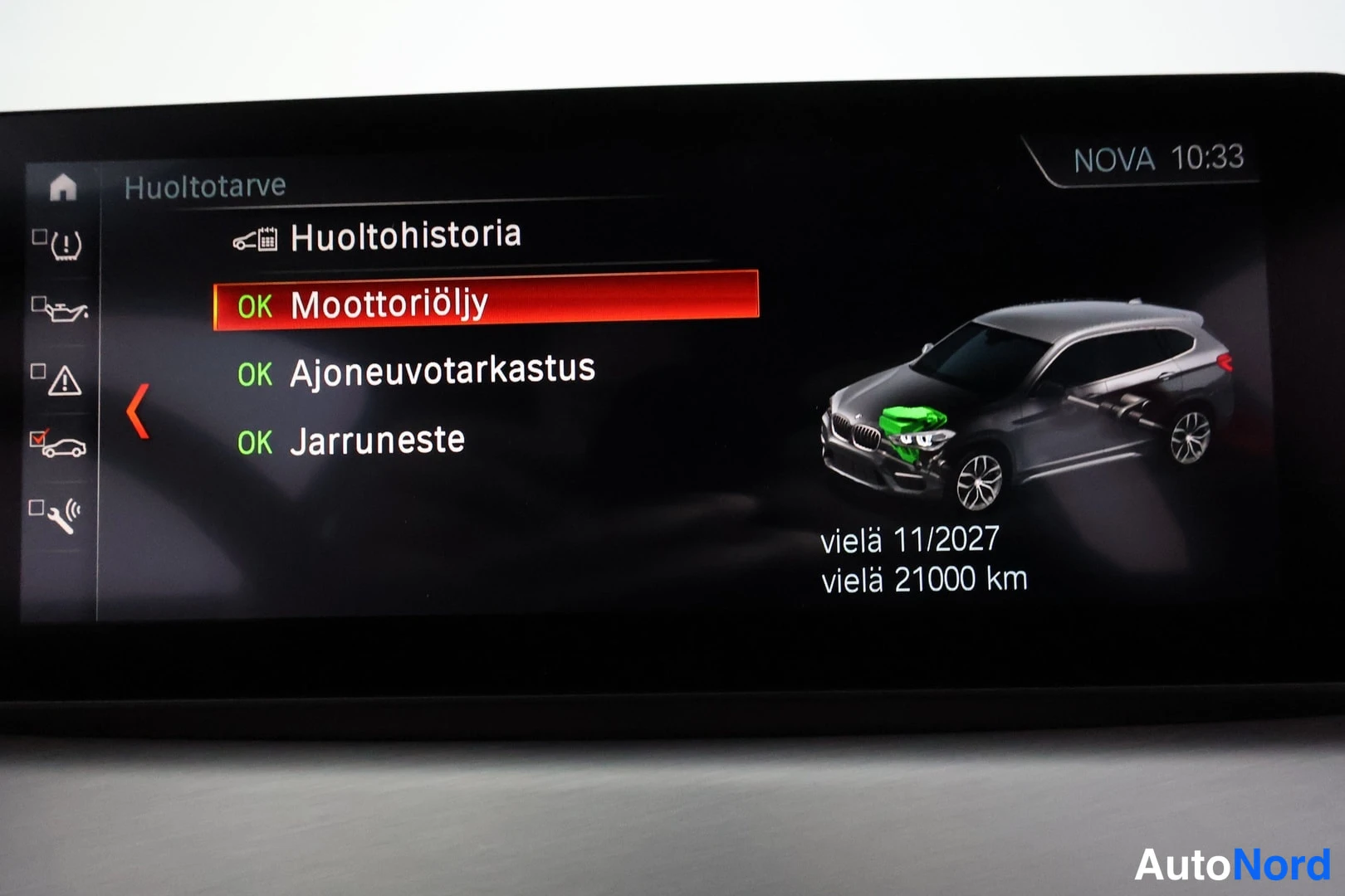 Yksityiskohta: Auton näytön huoltotarve -valikko: moottoriöljy, ajoneuvotarkastus ja jarruneste OK, voimassa 11/2027 asti ja 21.000 km.