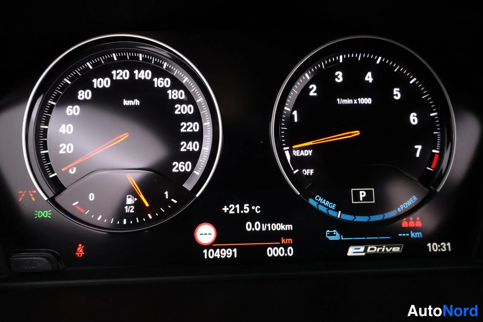 Muu: Mittaristo: nopeusmittari ja kierroslukumittari, matkamittari näyttää 104991 km, E Drive -merkintä.
